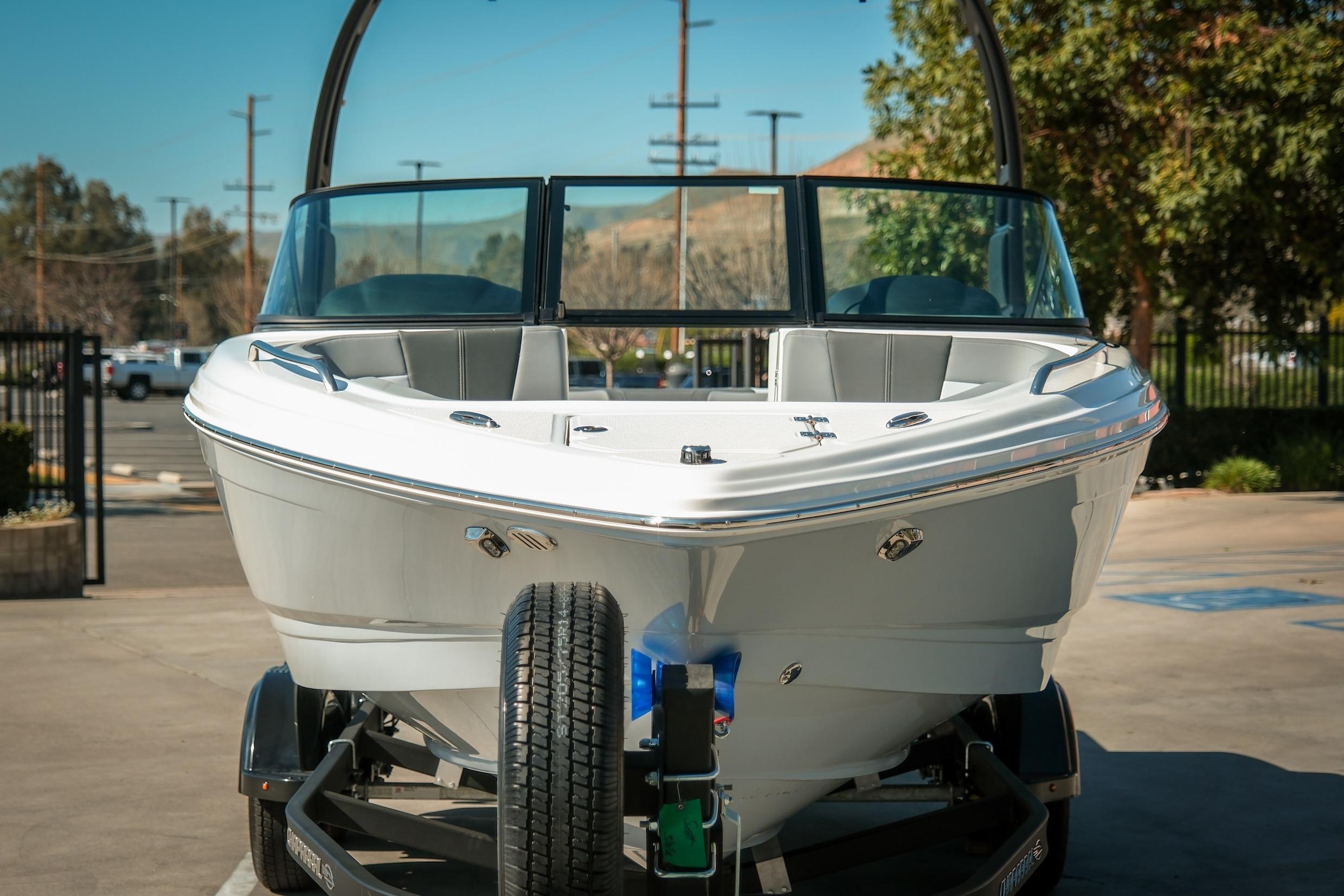 2026 Chaparral 23 SSi boat on trailer, front view, parked outdoors.