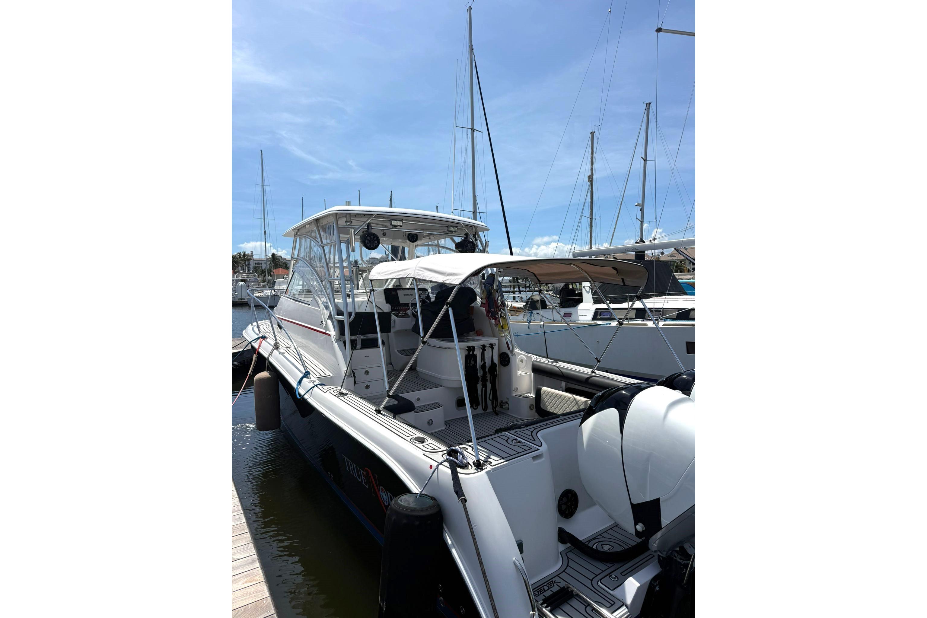 2006 Pro-Line 32 Express boat docked at marina under clear blue sky.