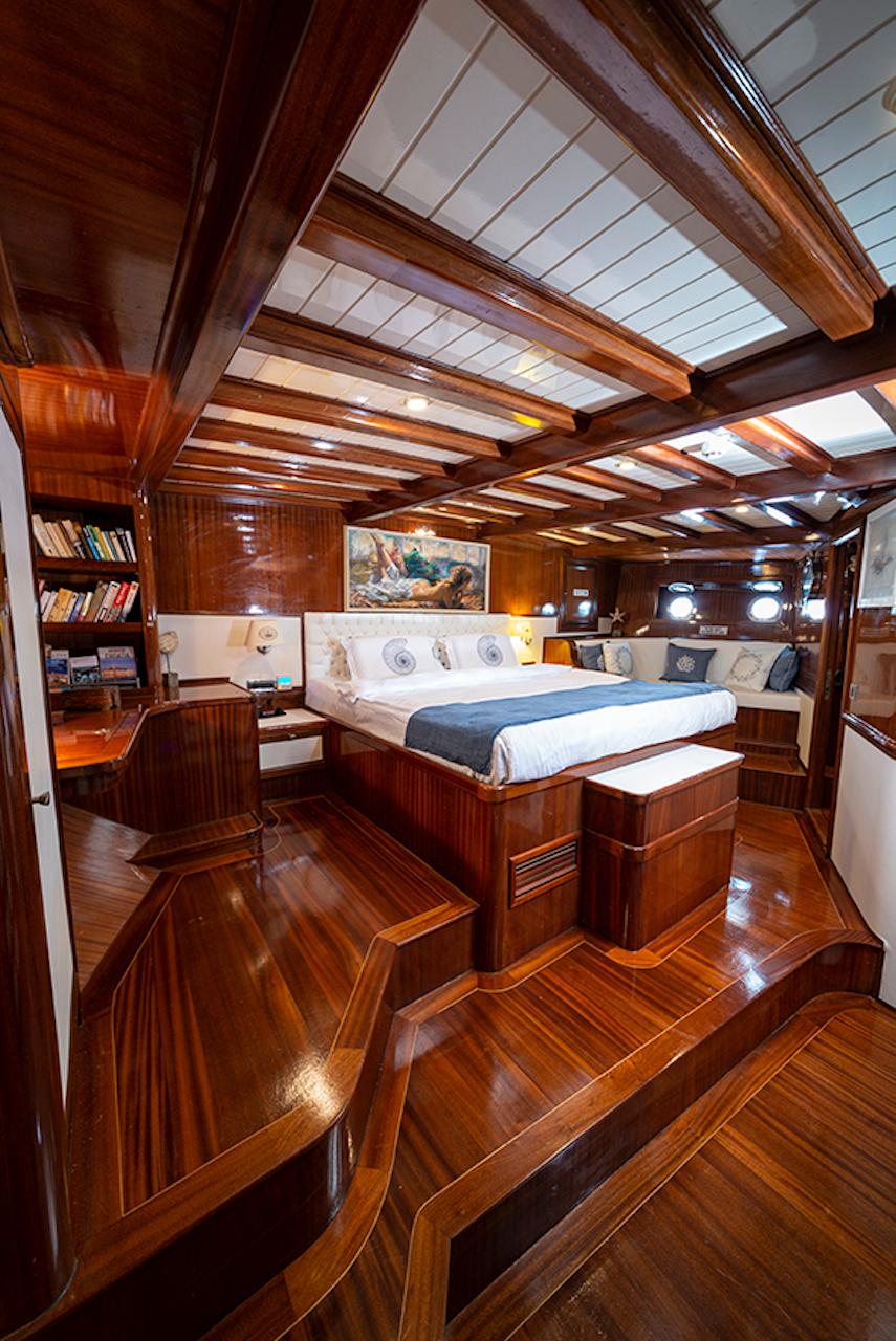 Luxurious 2009 custom motorsailer cabin with rich wood interiors and elegant furnishings.