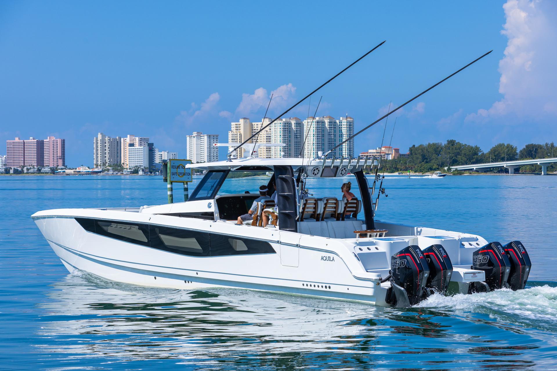 2024 Aquila 47 Molokai boat cruising near city skyline.