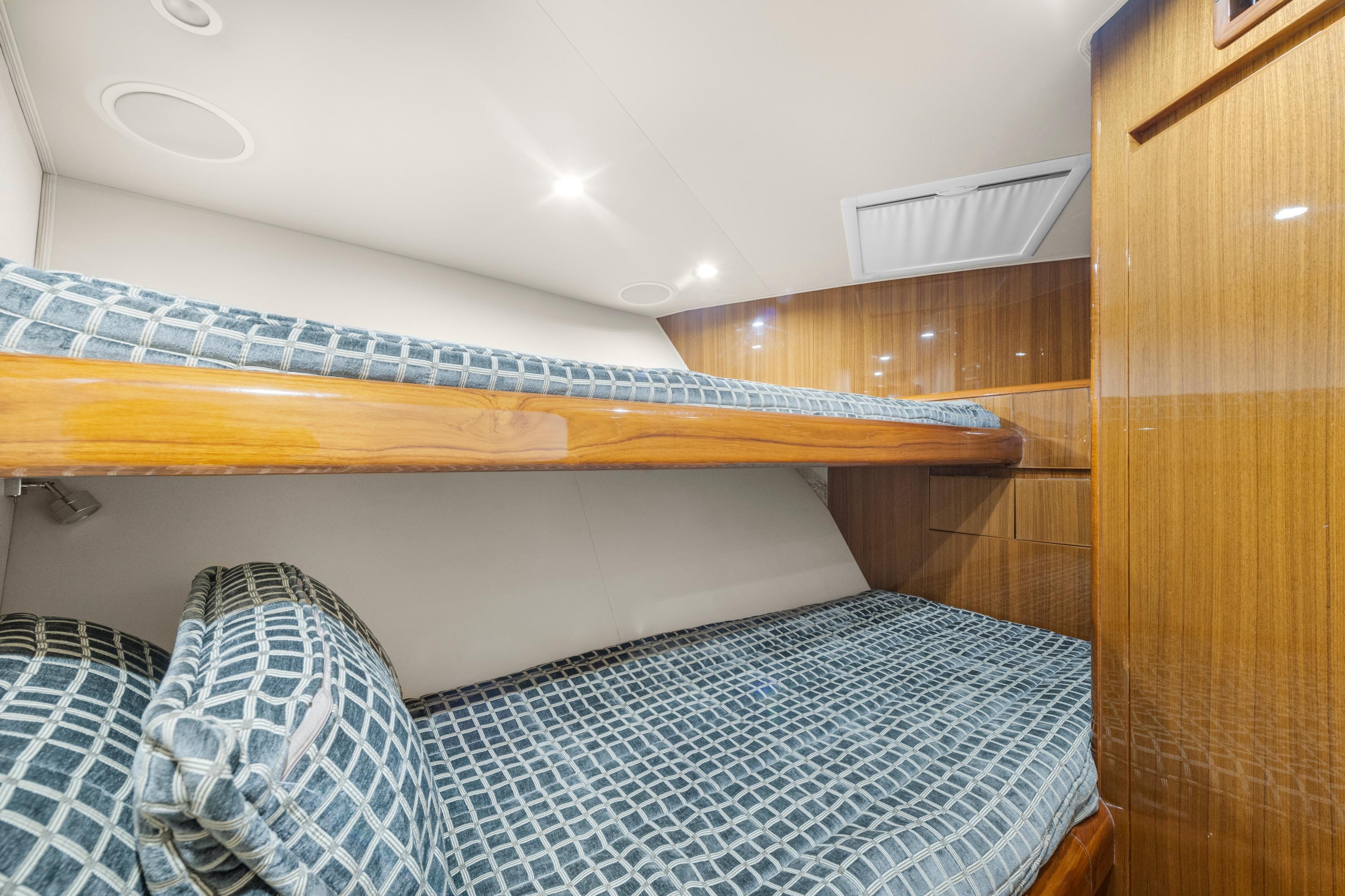 Interior of 2009 Viking 50 Convertible yacht with wooden bunk beds and patterned bedding.