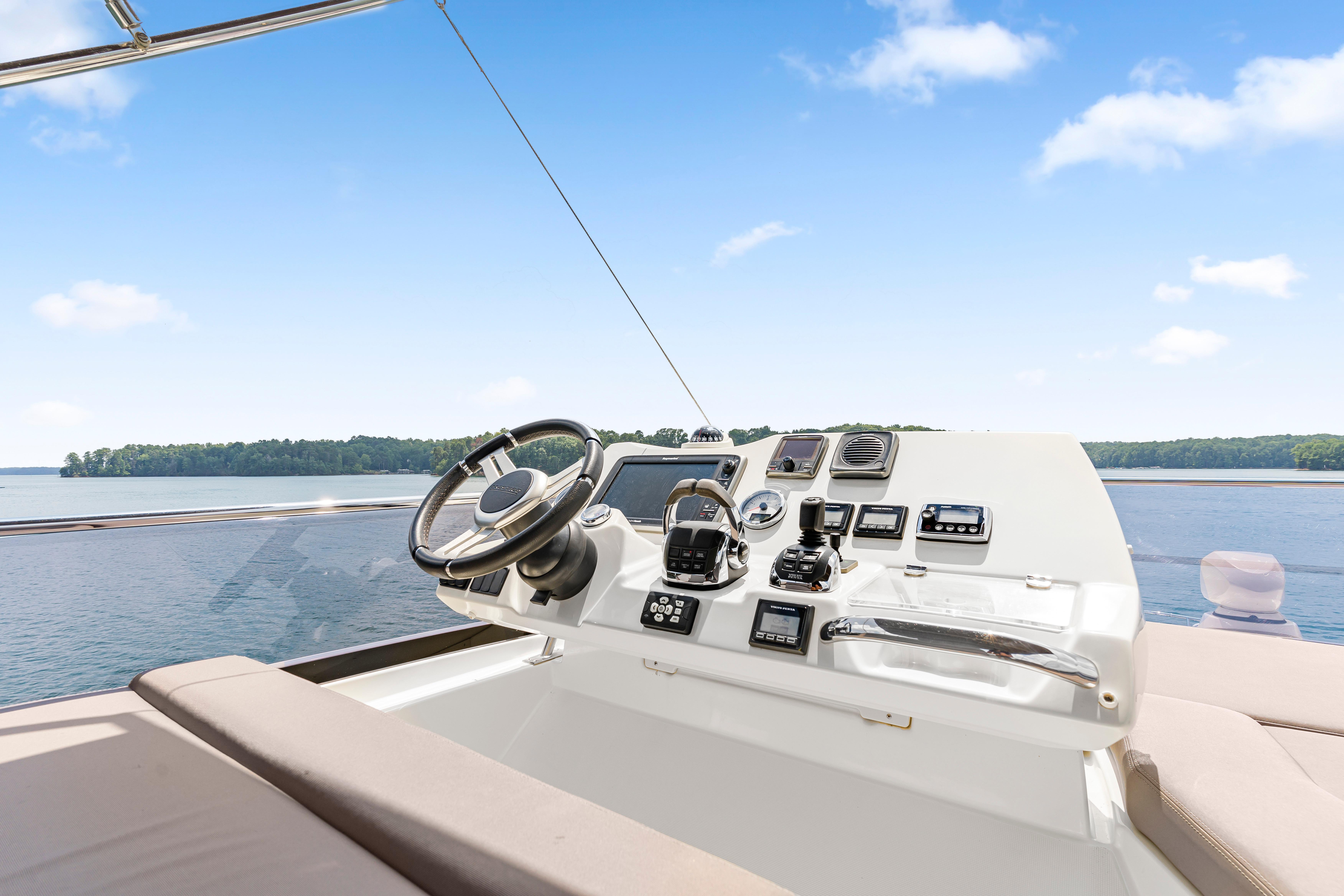Cockpit of 2017 Prestige 500 yacht with steering wheel and control panel on open water.