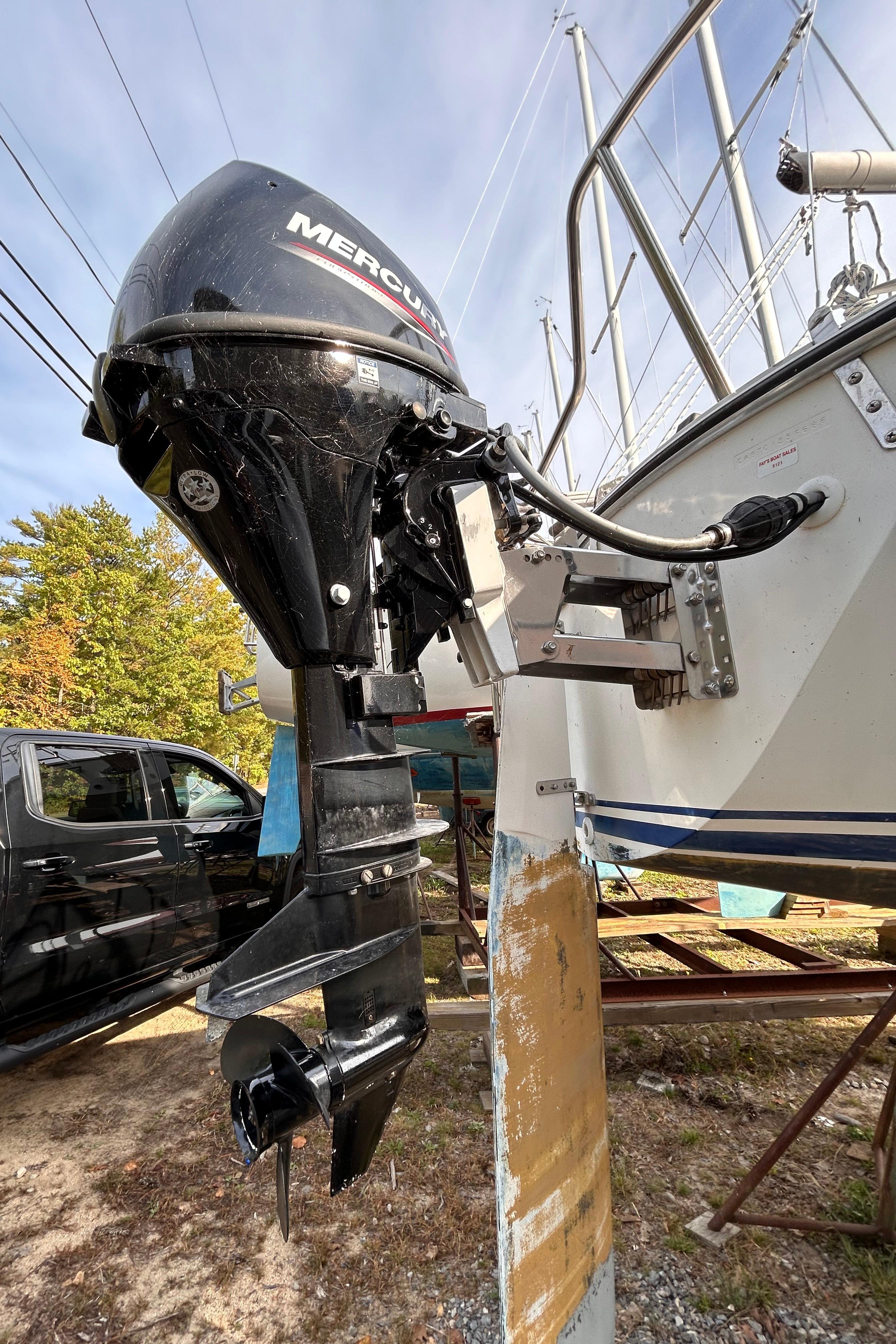 1986 CAL 22 sailboat with Mercury outboard motor, docked outdoors.