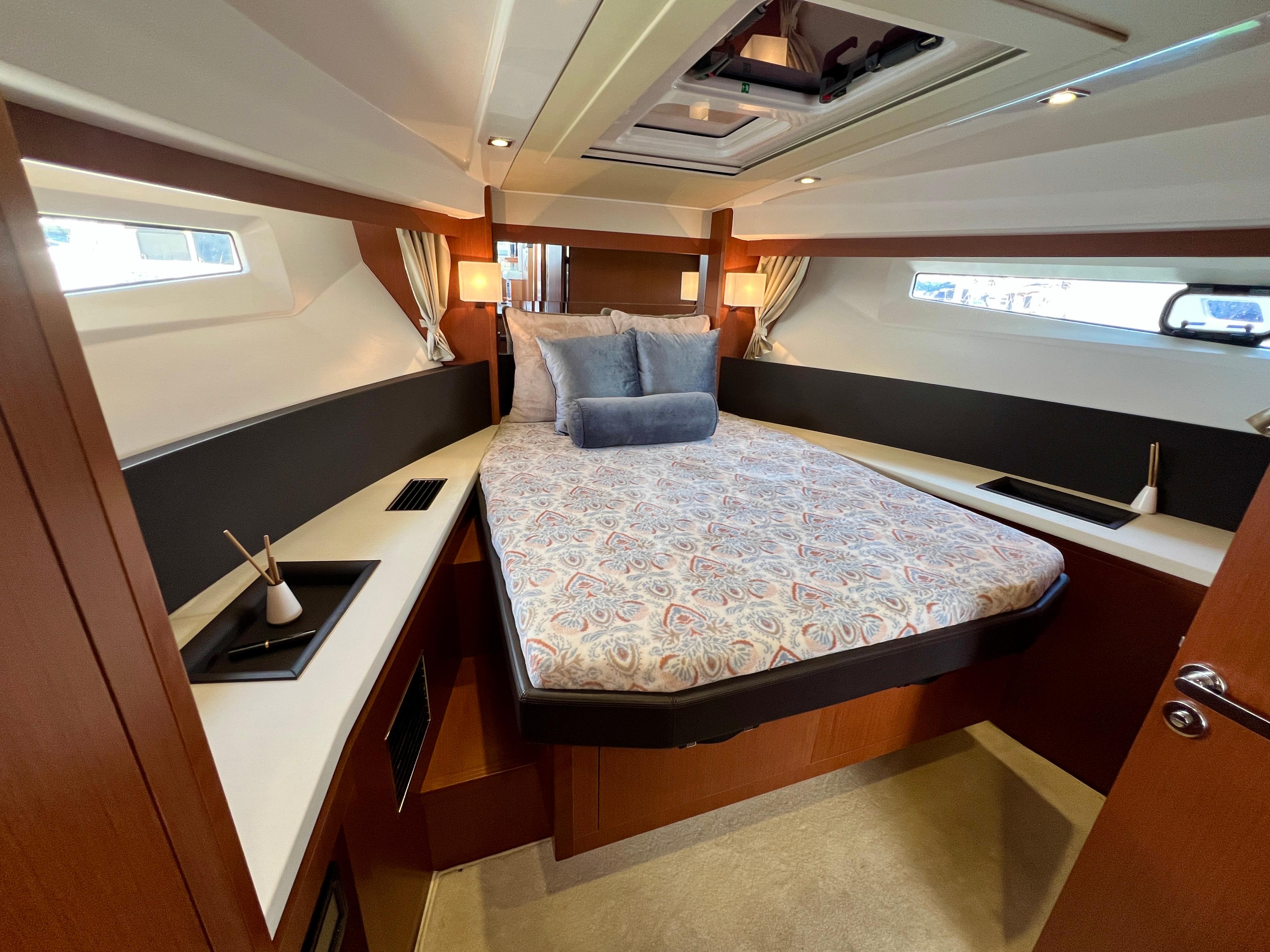 Luxurious cabin interior of 2017 Jeanneau Velasco 43 yacht with elegant bedding and modern design.