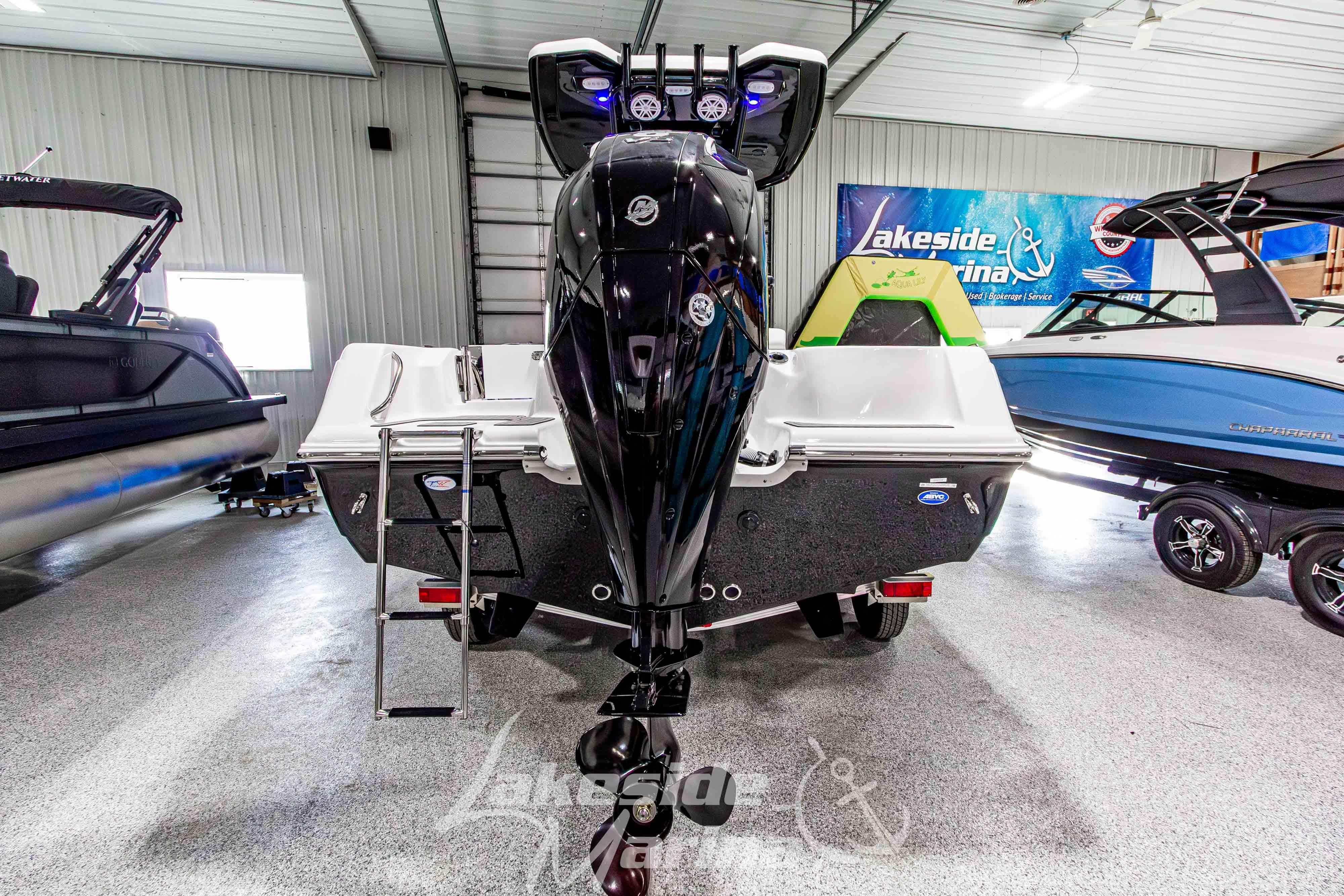 2026 Tidewater 210 CC Adventure boat in showroom, rear view with motor and ladder.