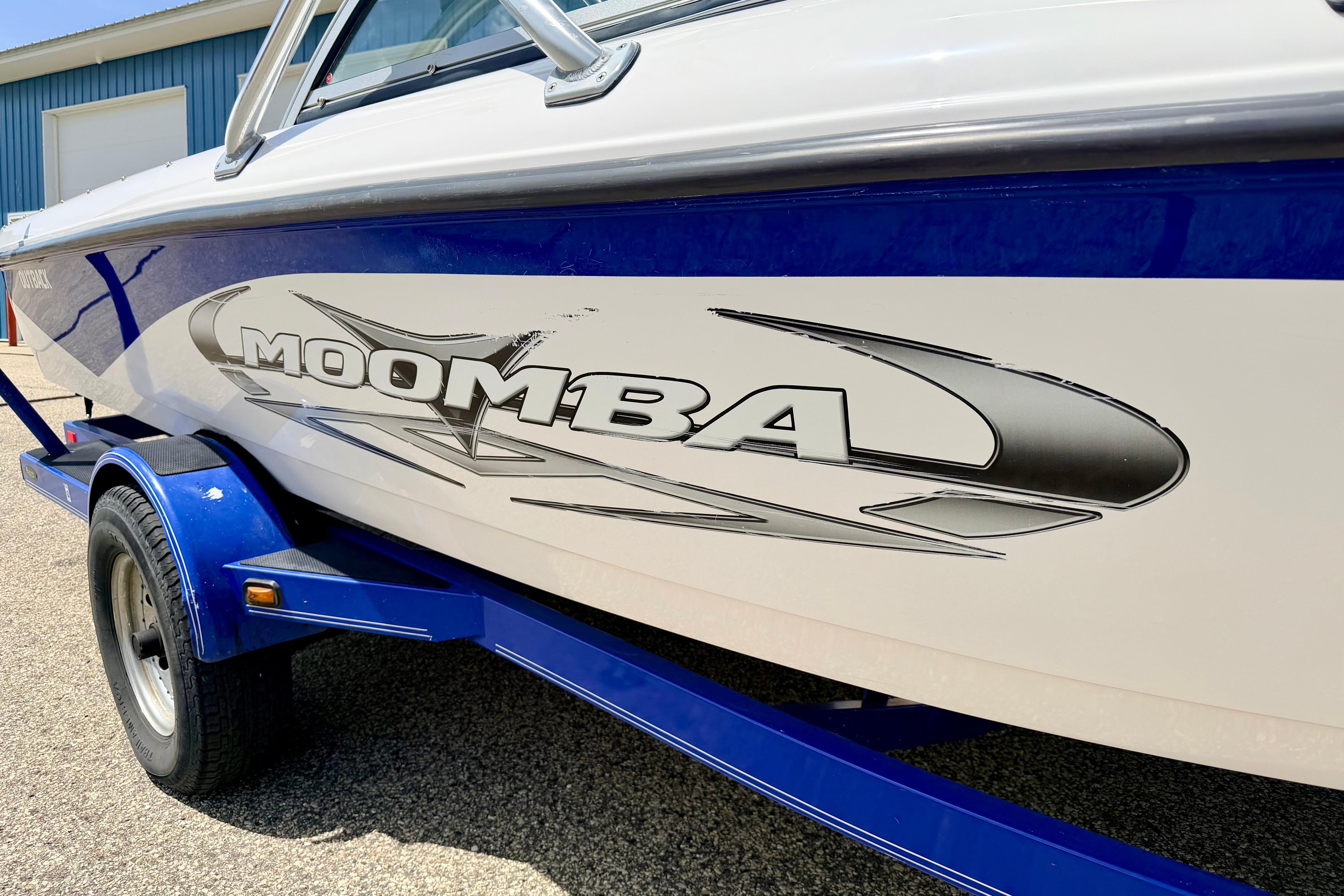 2008 Moomba Outback V boat on trailer, featuring sleek design and bold logo.