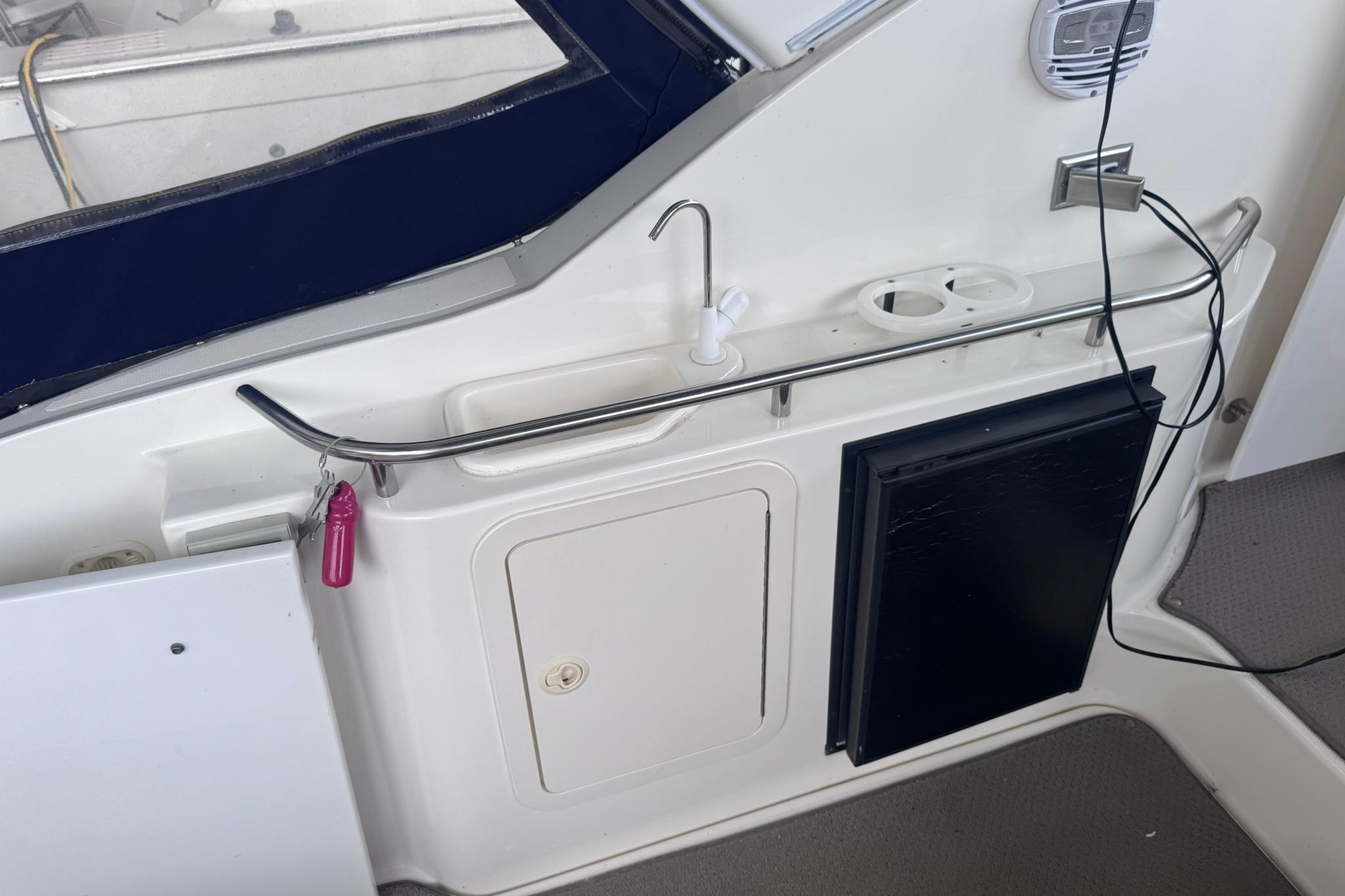 2002 Cruisers Yachts 3275 Express cockpit with sink, storage, and cup holders.