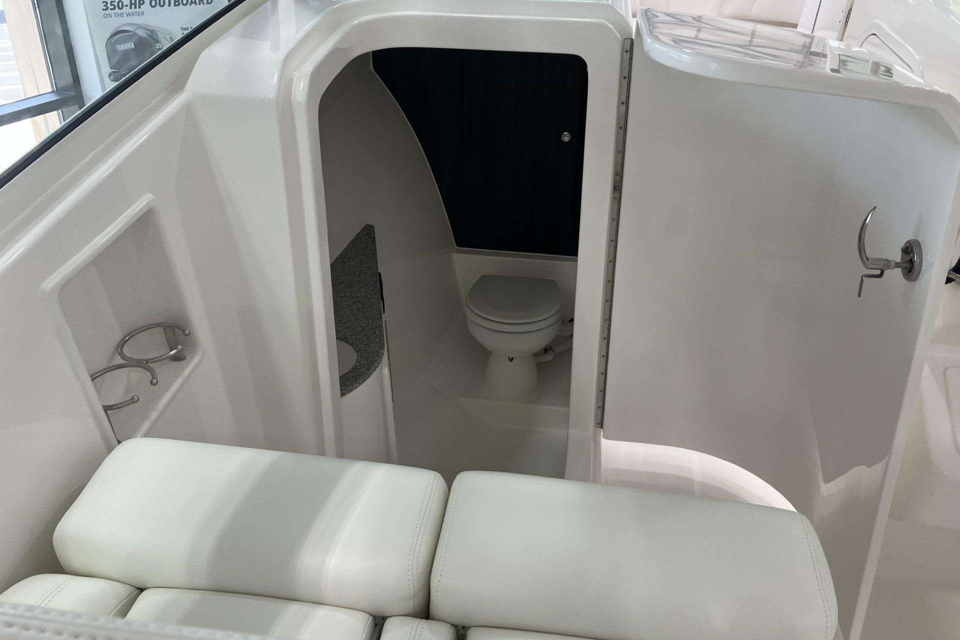 2026 Albemarle 27 Dual Console boat interior with compact bathroom and seating area.