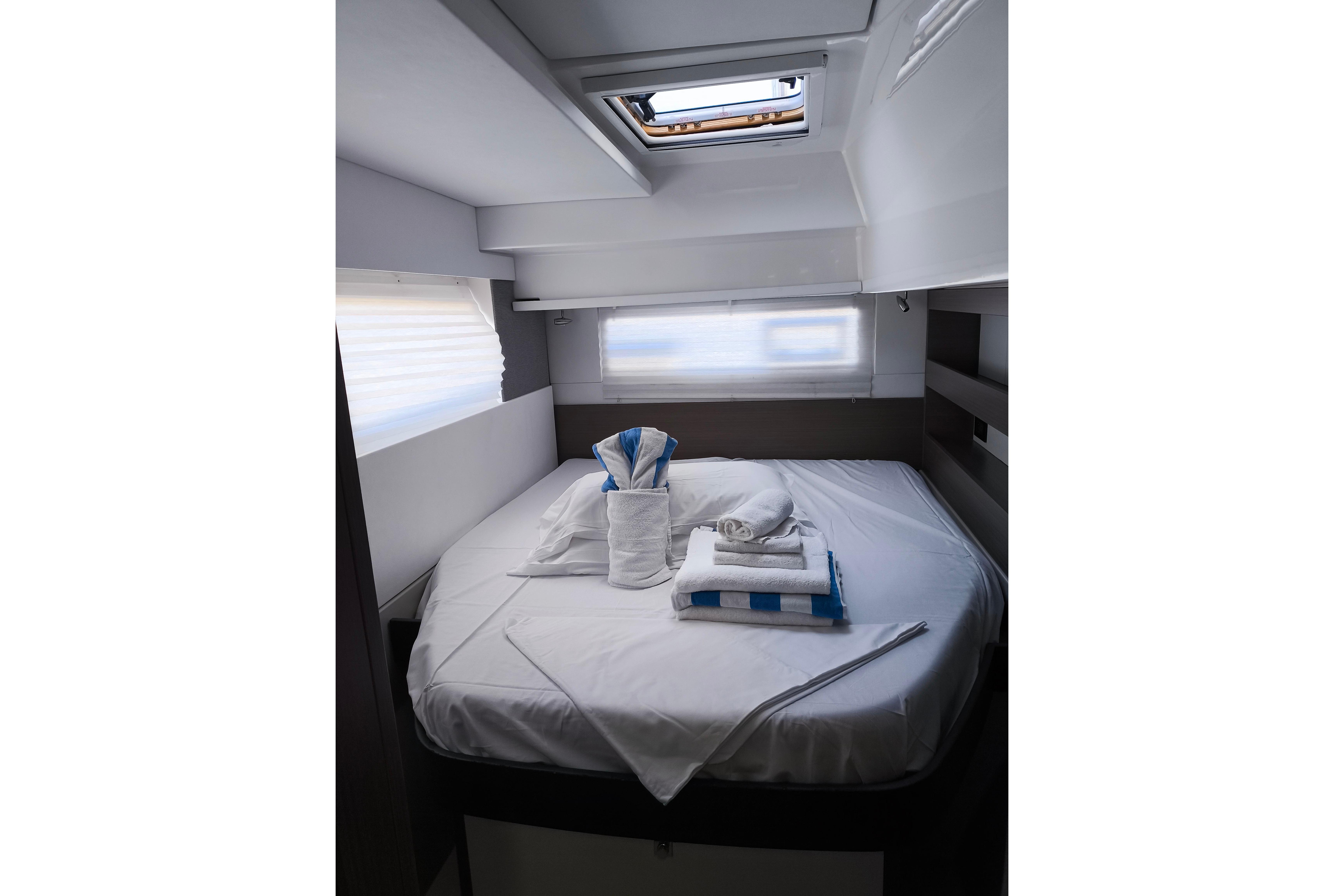 Luxurious cabin interior of 2021 Leopard 42 yacht with neatly arranged bed linens.