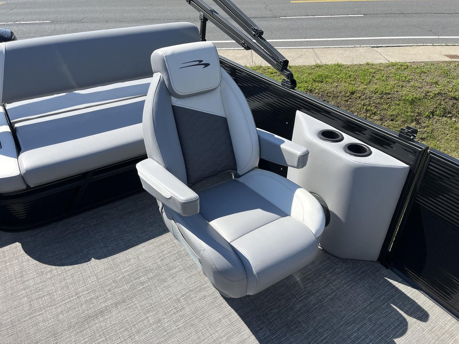 A luxurious seat on a Bennington S20 boat, featuring gray upholstery and cup holders.