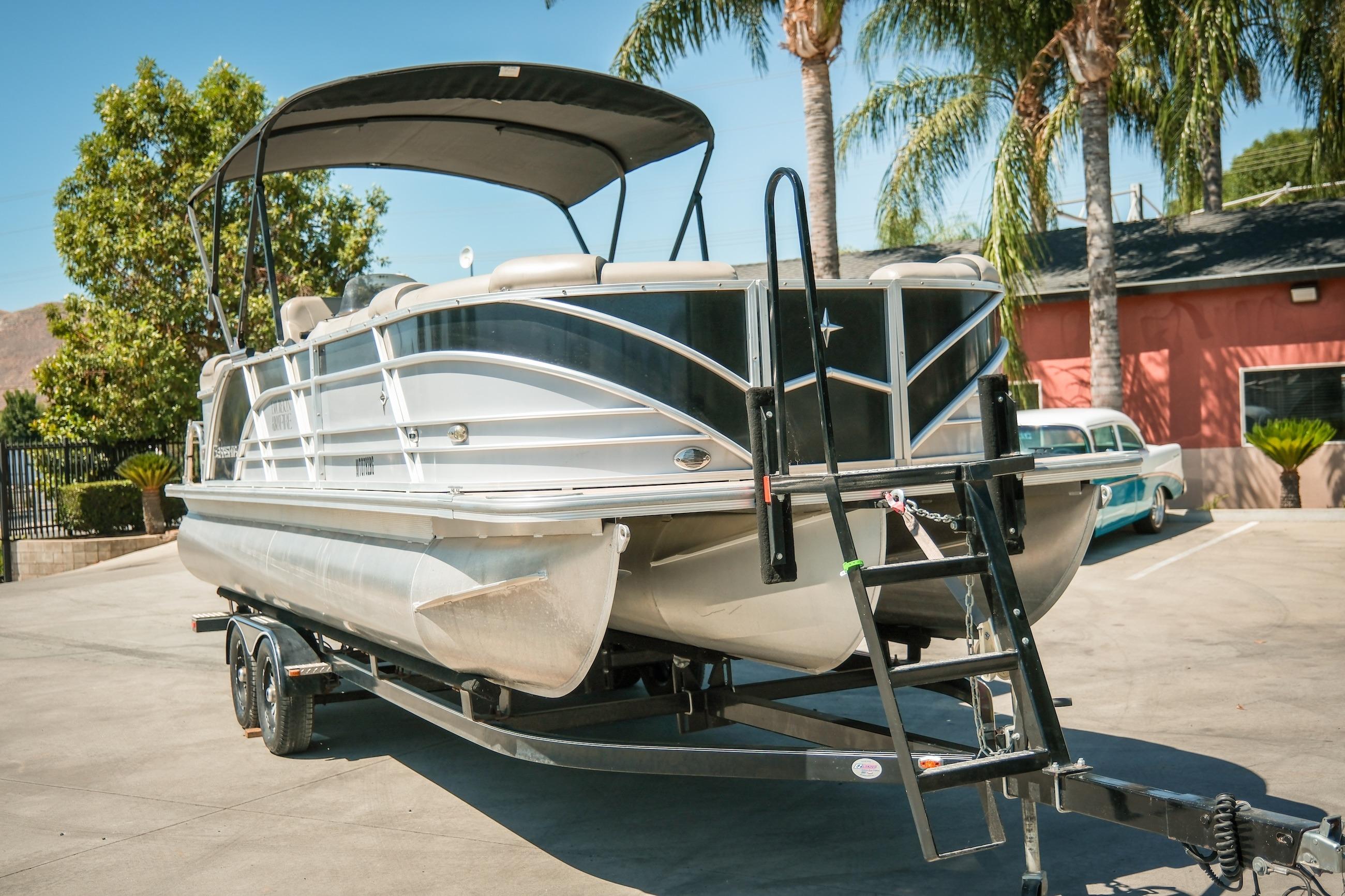 2019 Berkshire 25CLE STS pontoon boat on trailer, parked outdoors with palm trees.