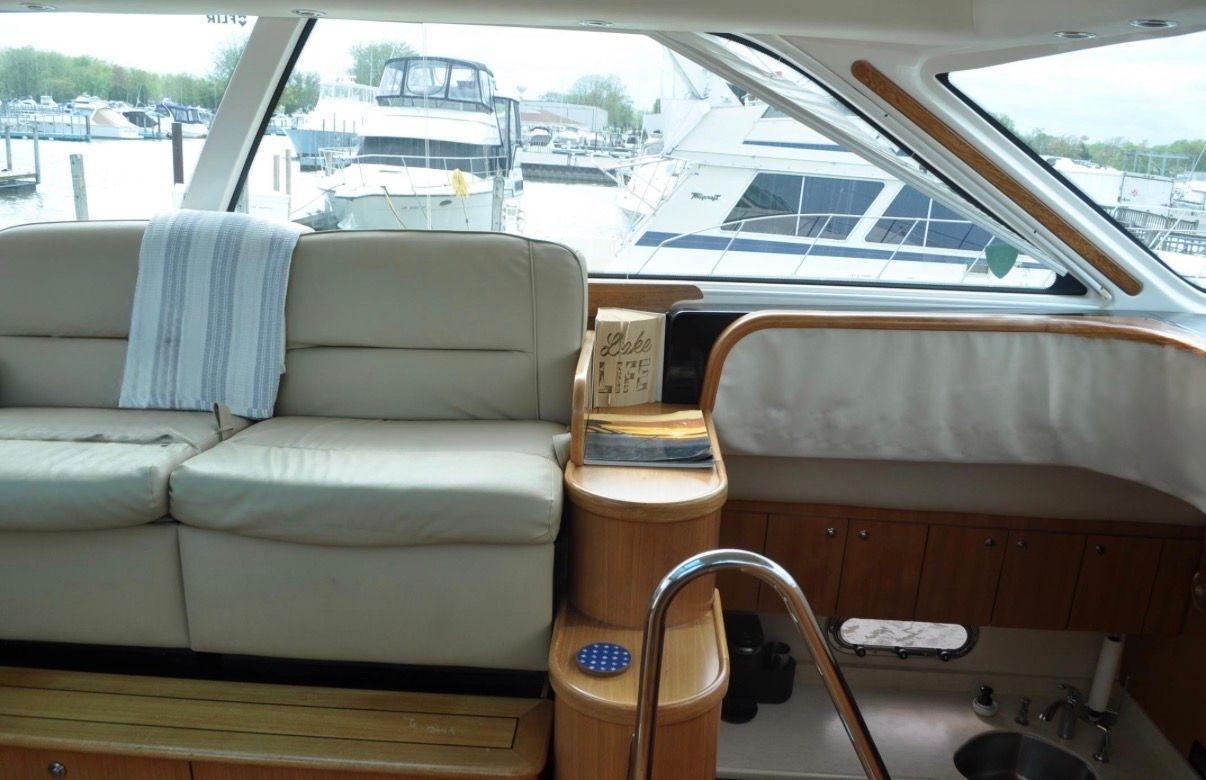 Interior of a 2005 Tiara Yachts 5200 Sovran with beige sofa and wood accents.