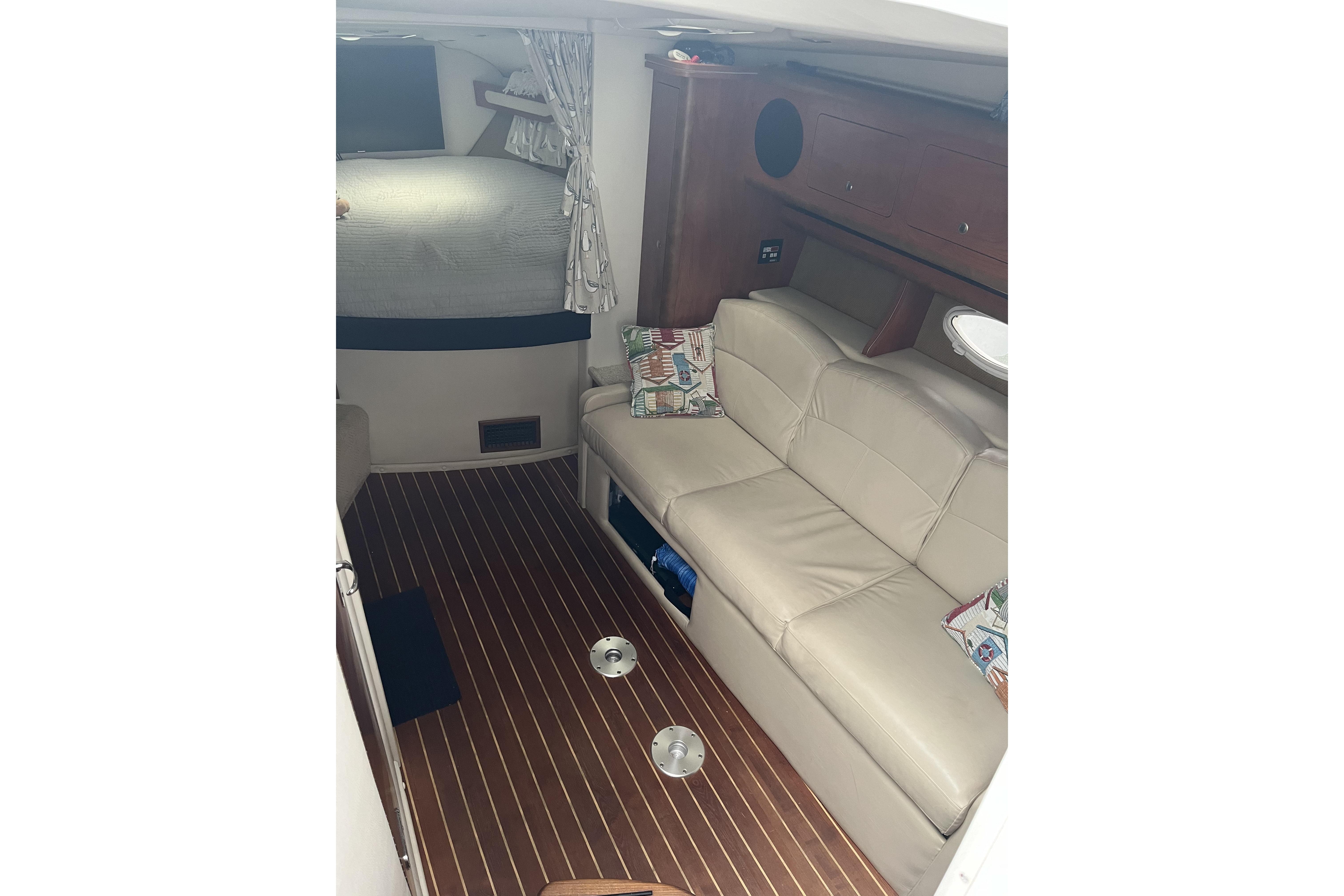 2008 Rinker 330 Express Cruiser interior with beige seating and wood flooring.