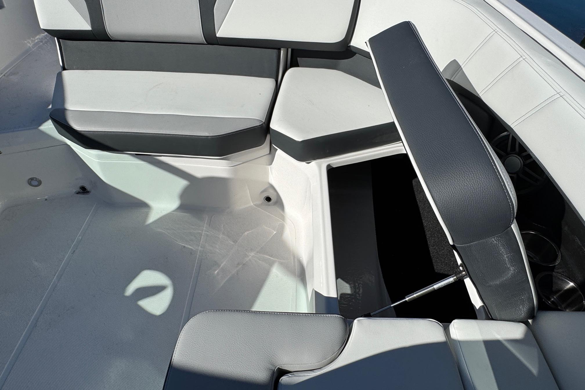 2026 Regal 21 OBX boat interior with open storage compartment and cushioned seating.