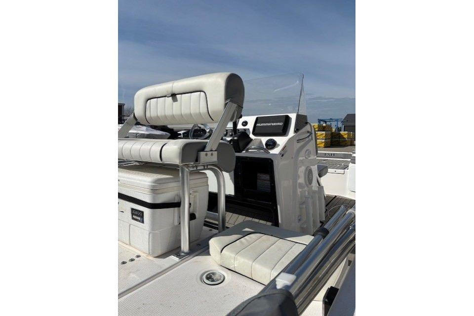 2022 Yamaha Boats 195 FSH Deluxe interior with seating and console, under clear sky.