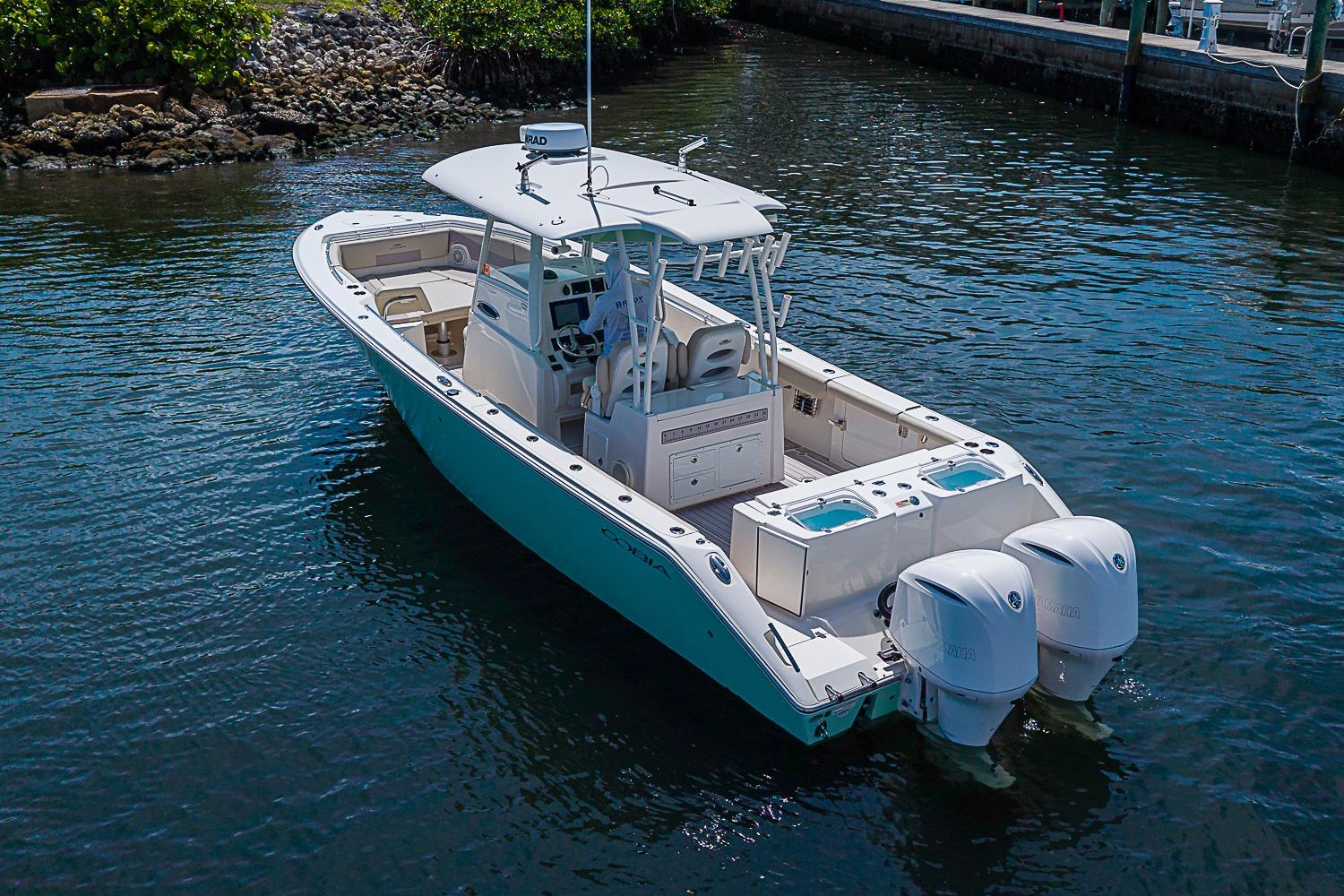 2019 Cobia 320 Center Console boat with dual engines on calm water.