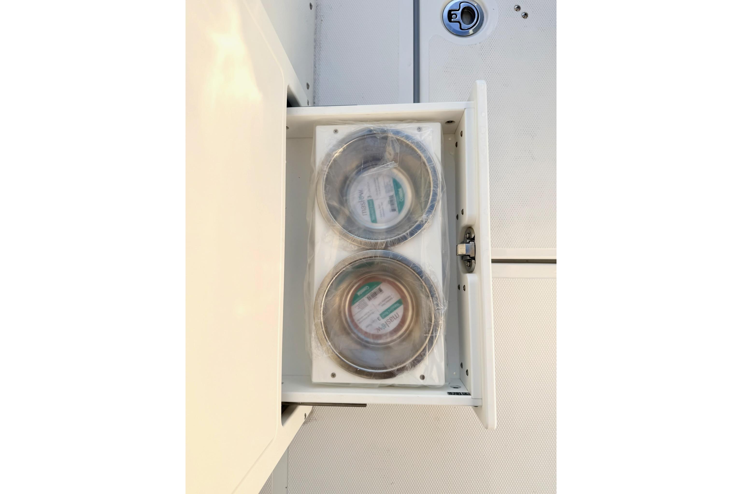 Storage compartment with two sealed containers on a 2026 Sea Hunt Ultra 275 Coffin Box boat.