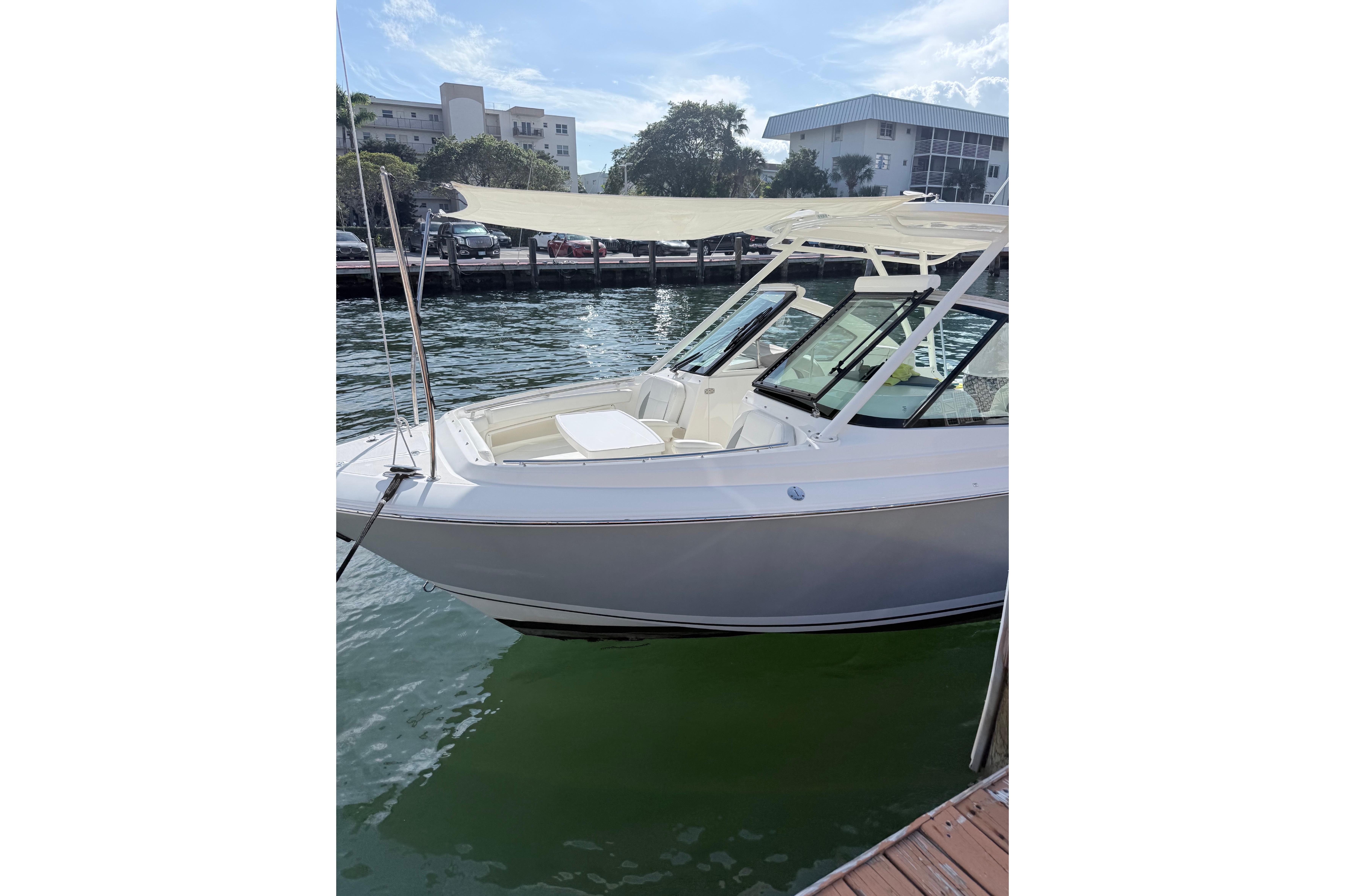 2022 Pursuit DC 266 Dual Console boat docked by the water.