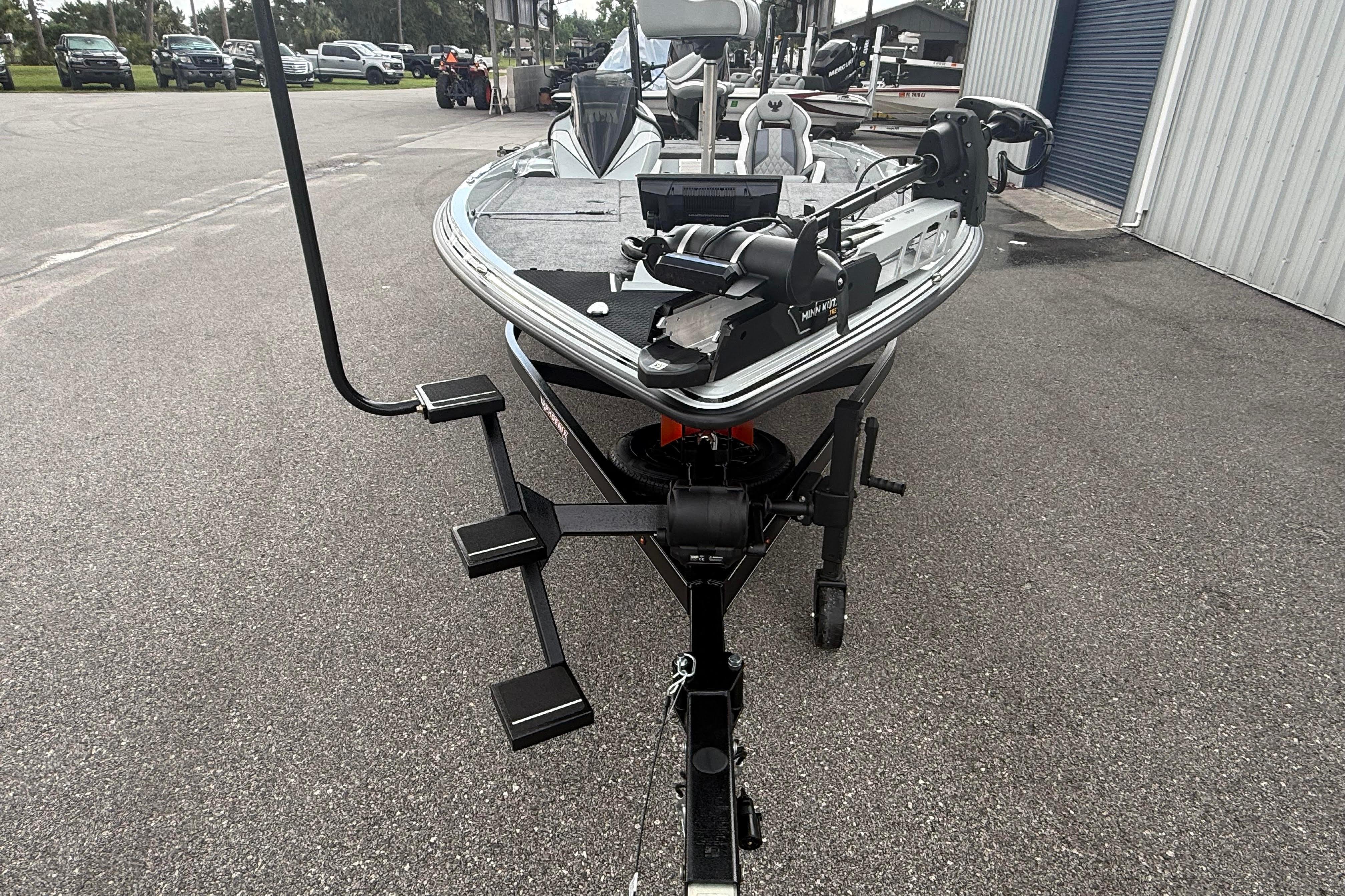 2027 Phoenix 921 Elite X II boat on trailer, parked outdoors near a building.
