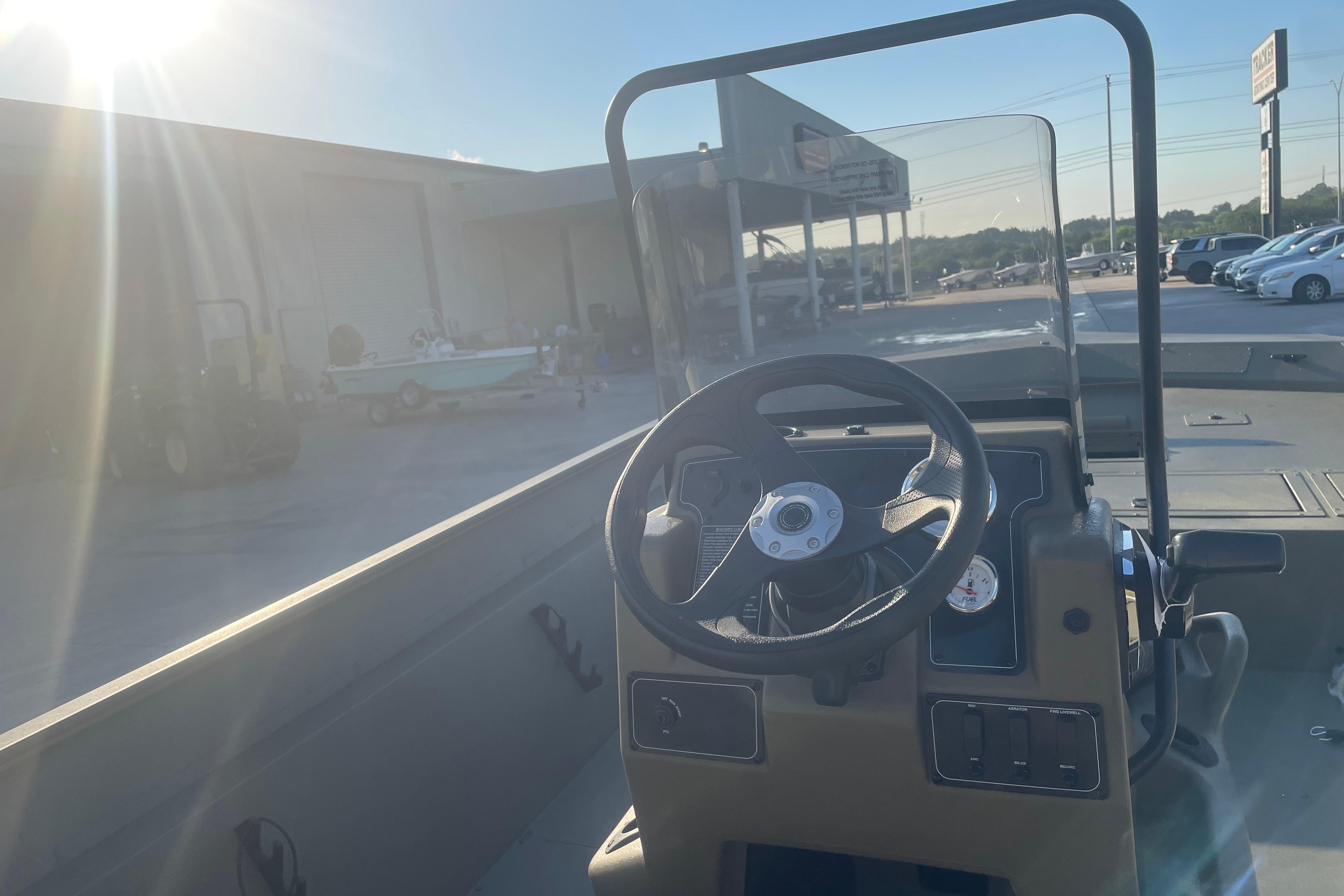 2026 Tracker Grizzly 2072 CC boat interior with steering wheel and dashboard in sunlight.