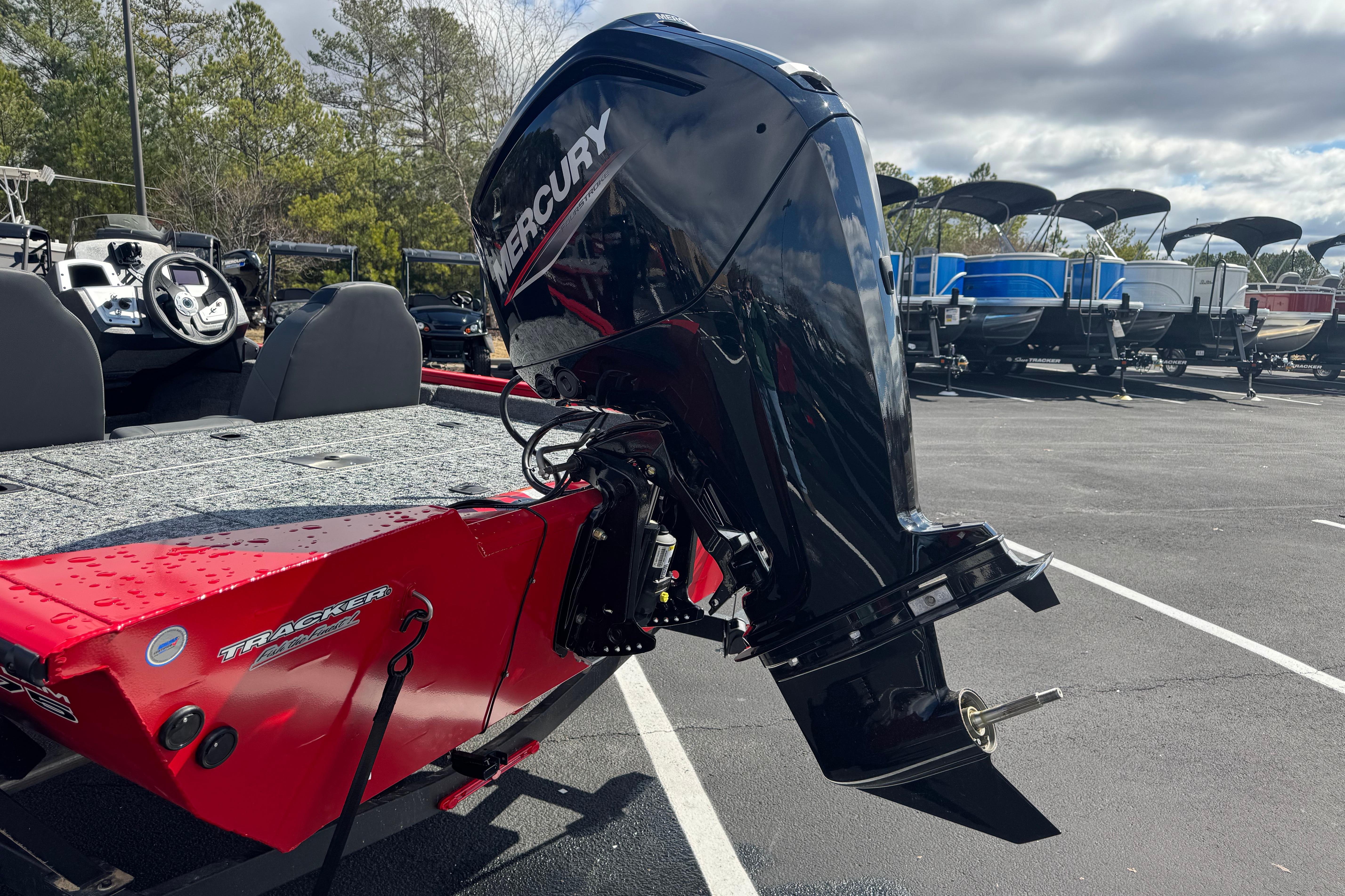 2026 Tracker Pro Team 175 boat with Mercury outboard motor in parking lot.