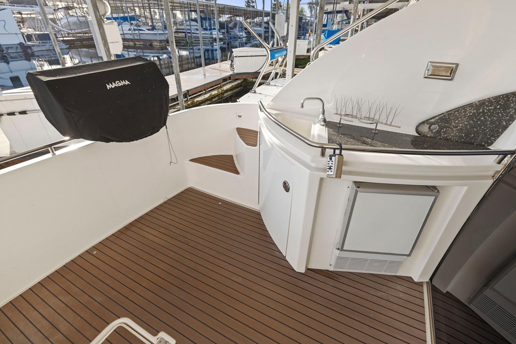 2008 Cruisers Yachts 447 Sport Sedan deck with sink and grill, docked at marina.
