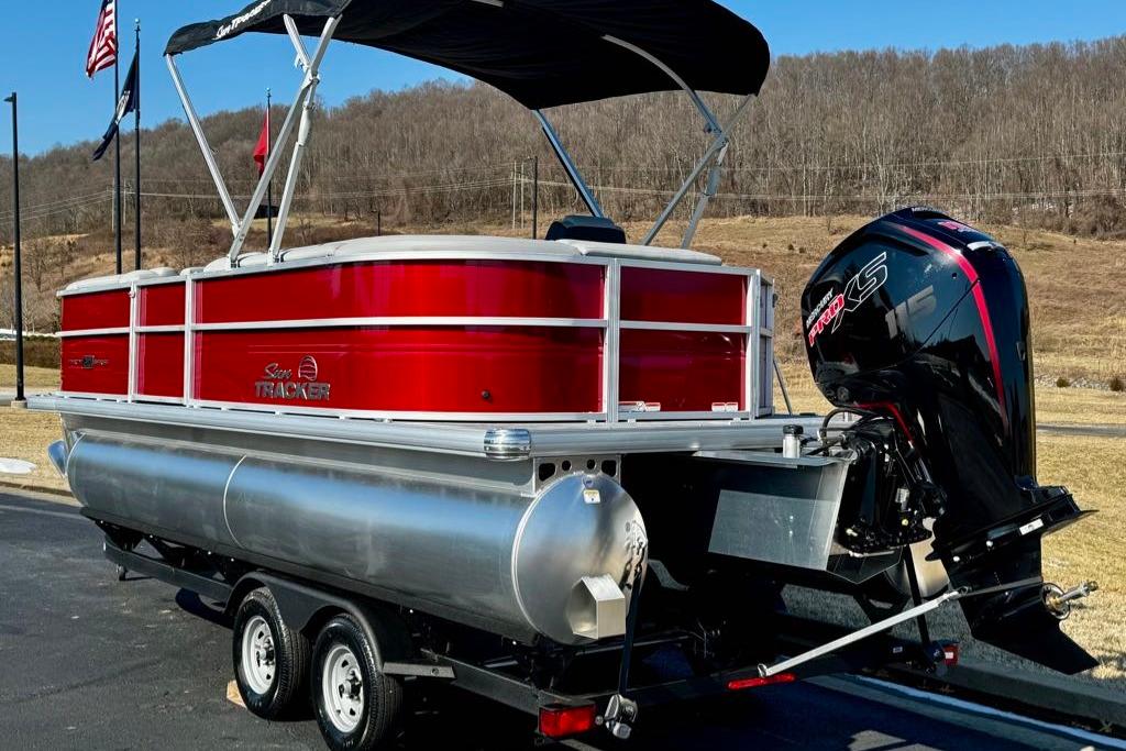 2026 Sun Tracker Party Barge 20 DLX pontoon boat with outboard motor on trailer.