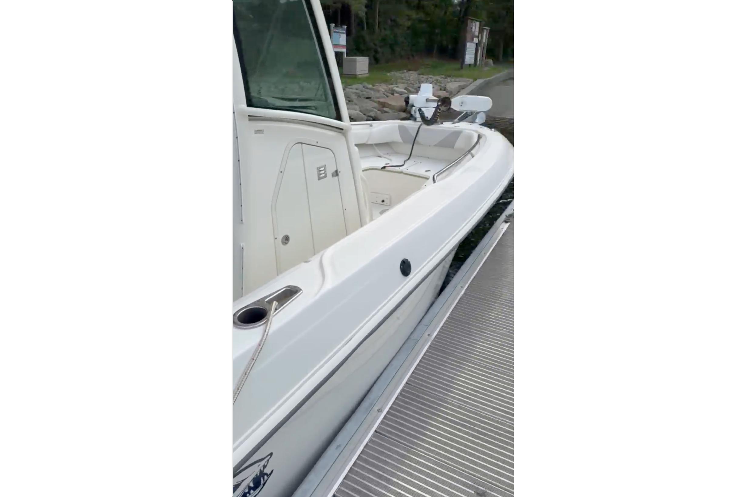 2023 Boston Whaler 250 Outrage boat docked, showcasing sleek white design and spacious deck.
