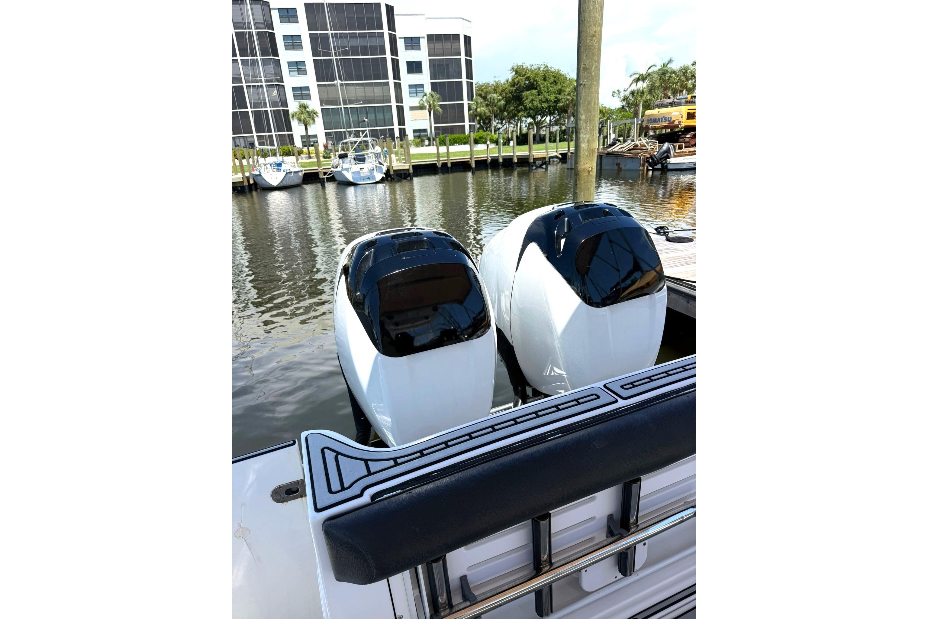 2006 Pro-Line 32 Express boat with dual outboard engines docked in marina.