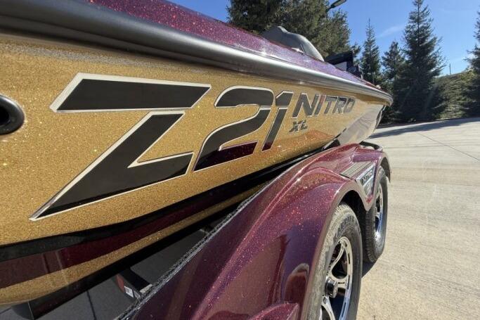 2026 Nitro Z21 XL Pro boat with gold and maroon detailing, parked outdoors.