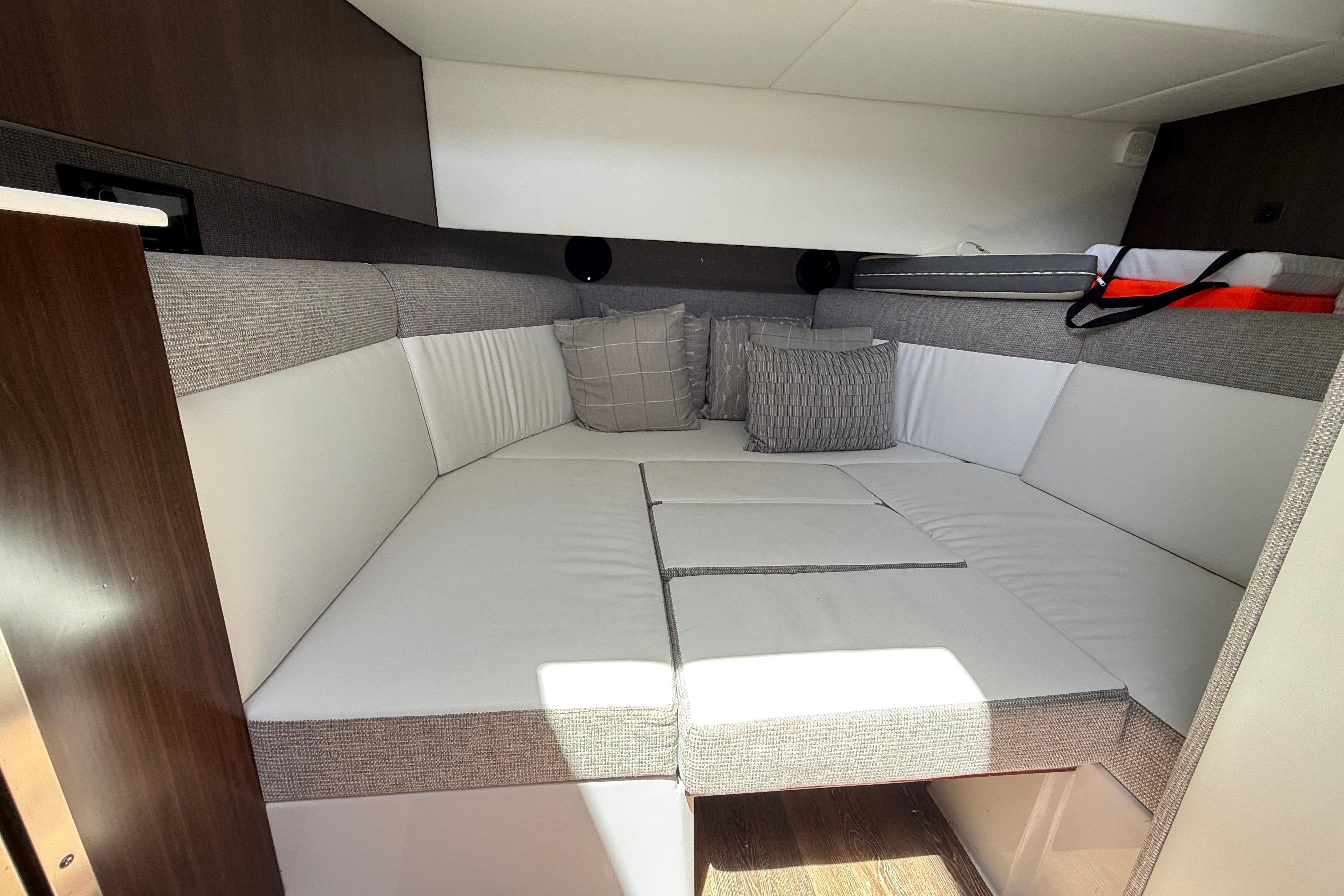 Interior cabin of 2021 Cruisers Yachts 38 GLS OB with cushioned seating and pillows.