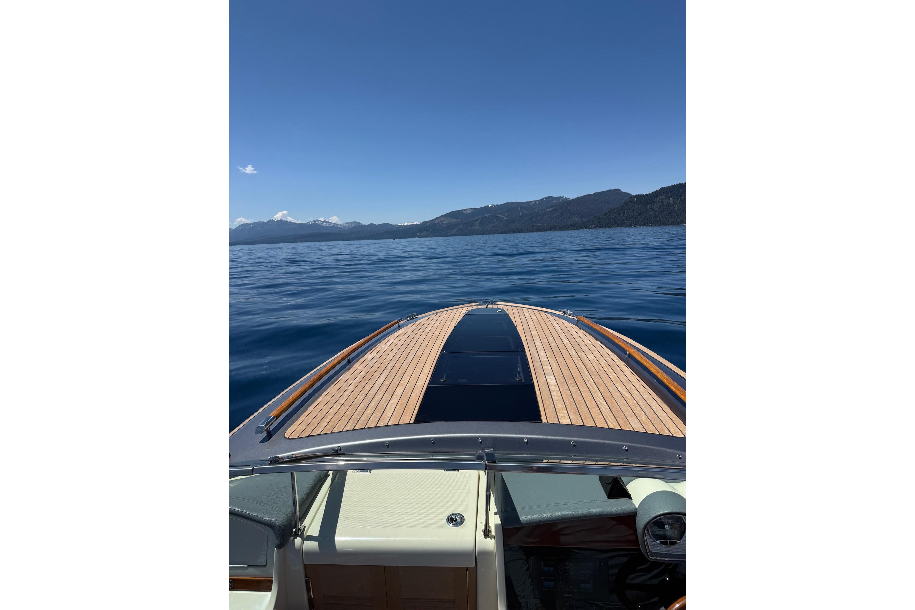 2021 Chris-Craft Corsair 34 cruising on a serene lake with mountain views.
