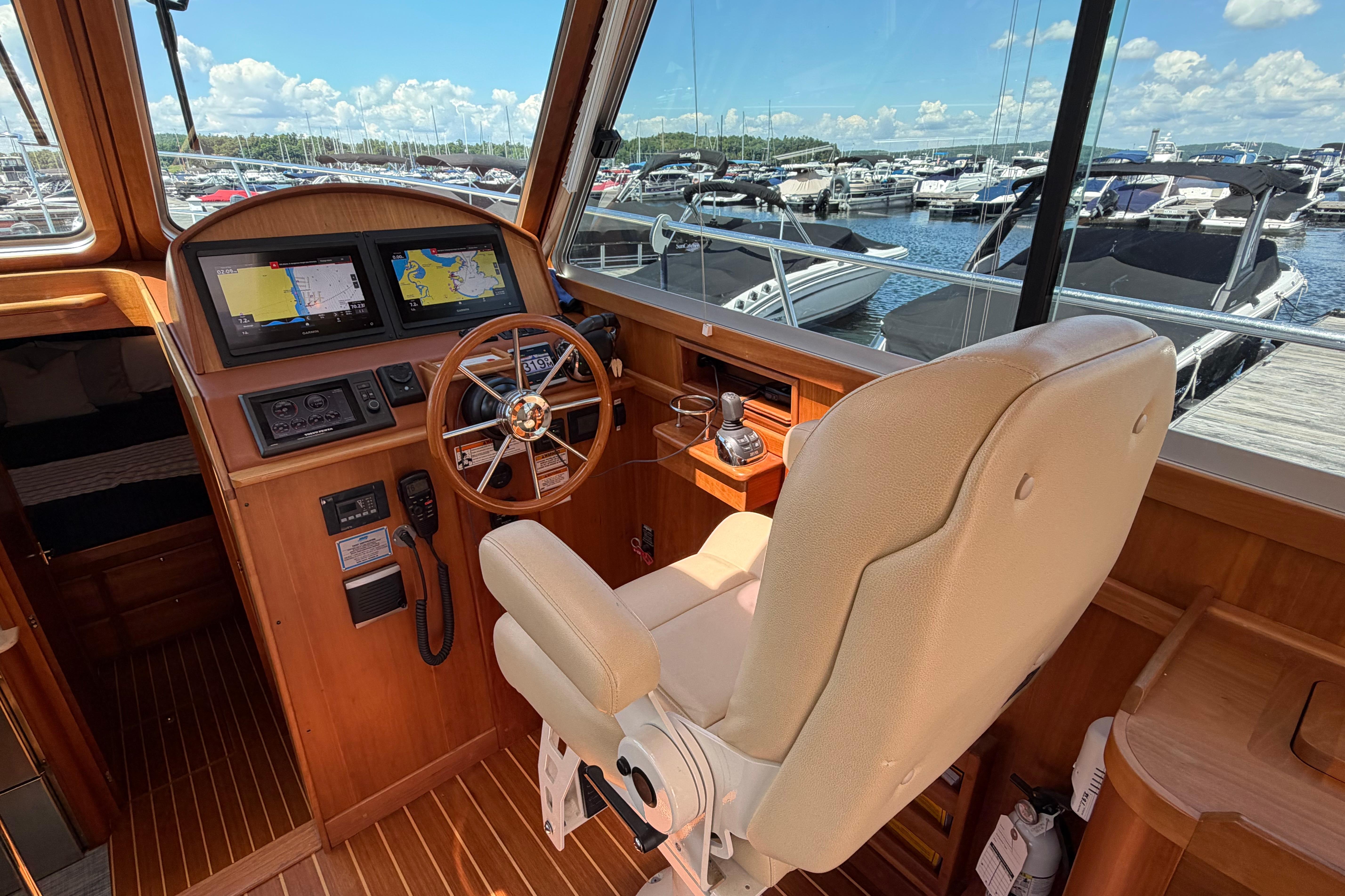Helm of 2015 Sabre 38 Salon Express with navigation screens and leather captain's chair.