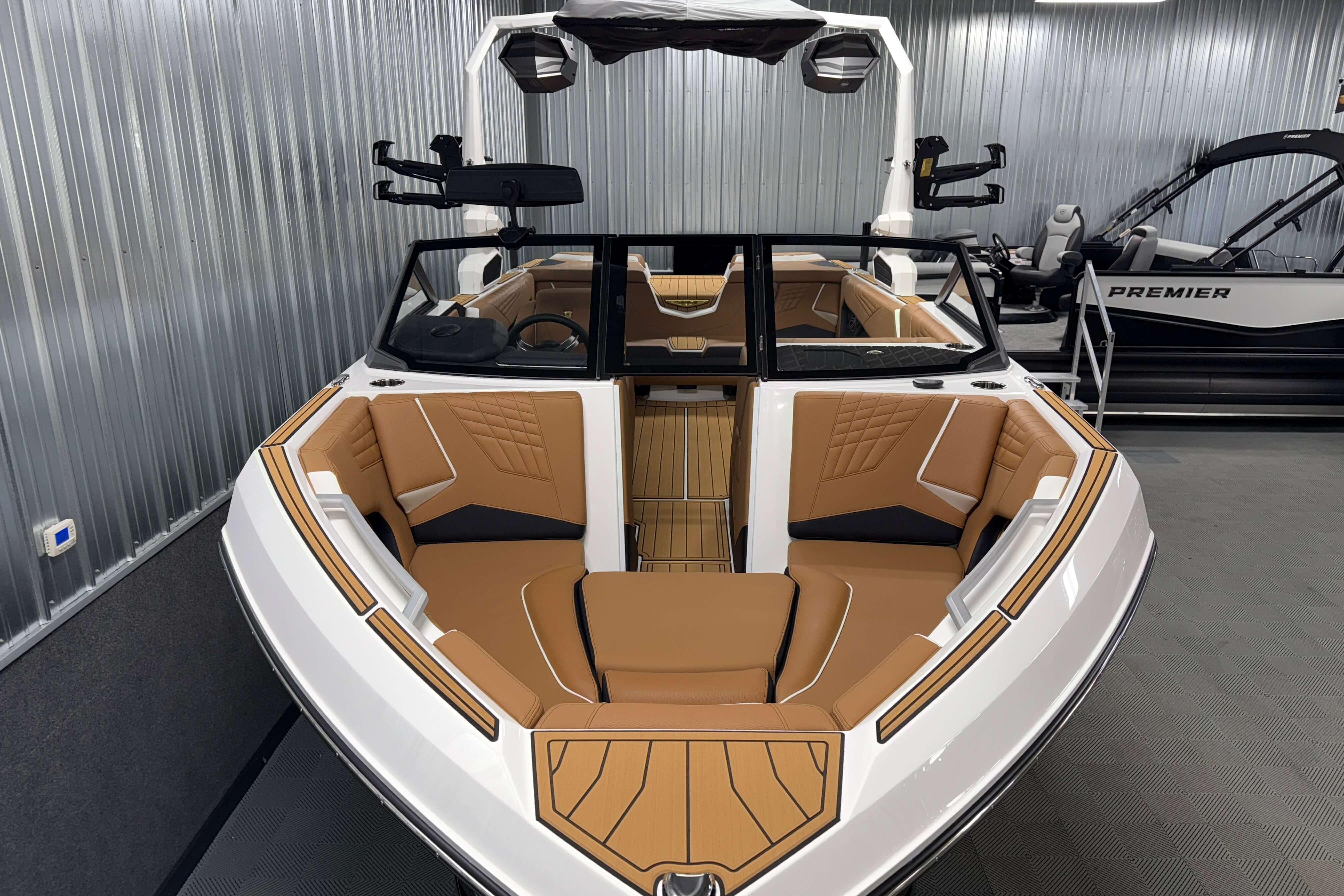 2026 Nautique Super Air Nautique S23 boat with luxurious tan seating in a showroom.