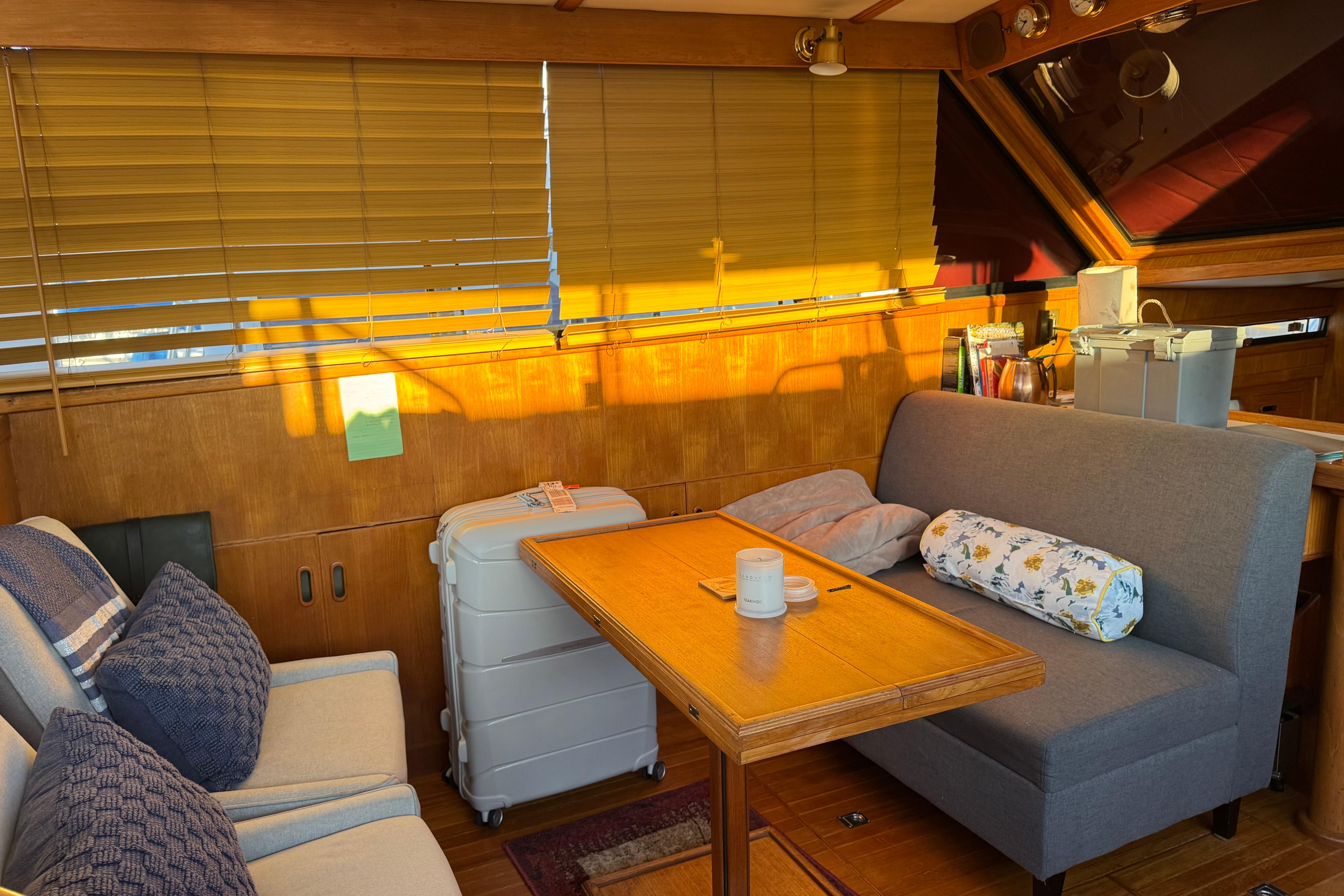 Cozy interior of a 1987 President 37 yacht with seating and wooden accents.
