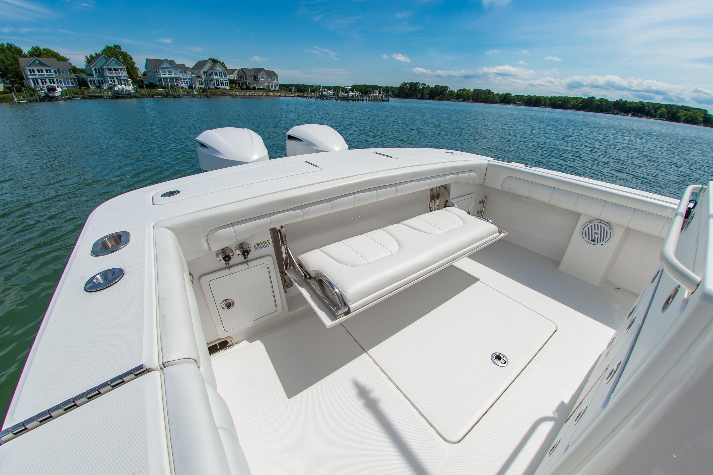 2019 Regulator 31 boat with white seating, docked near waterfront homes.