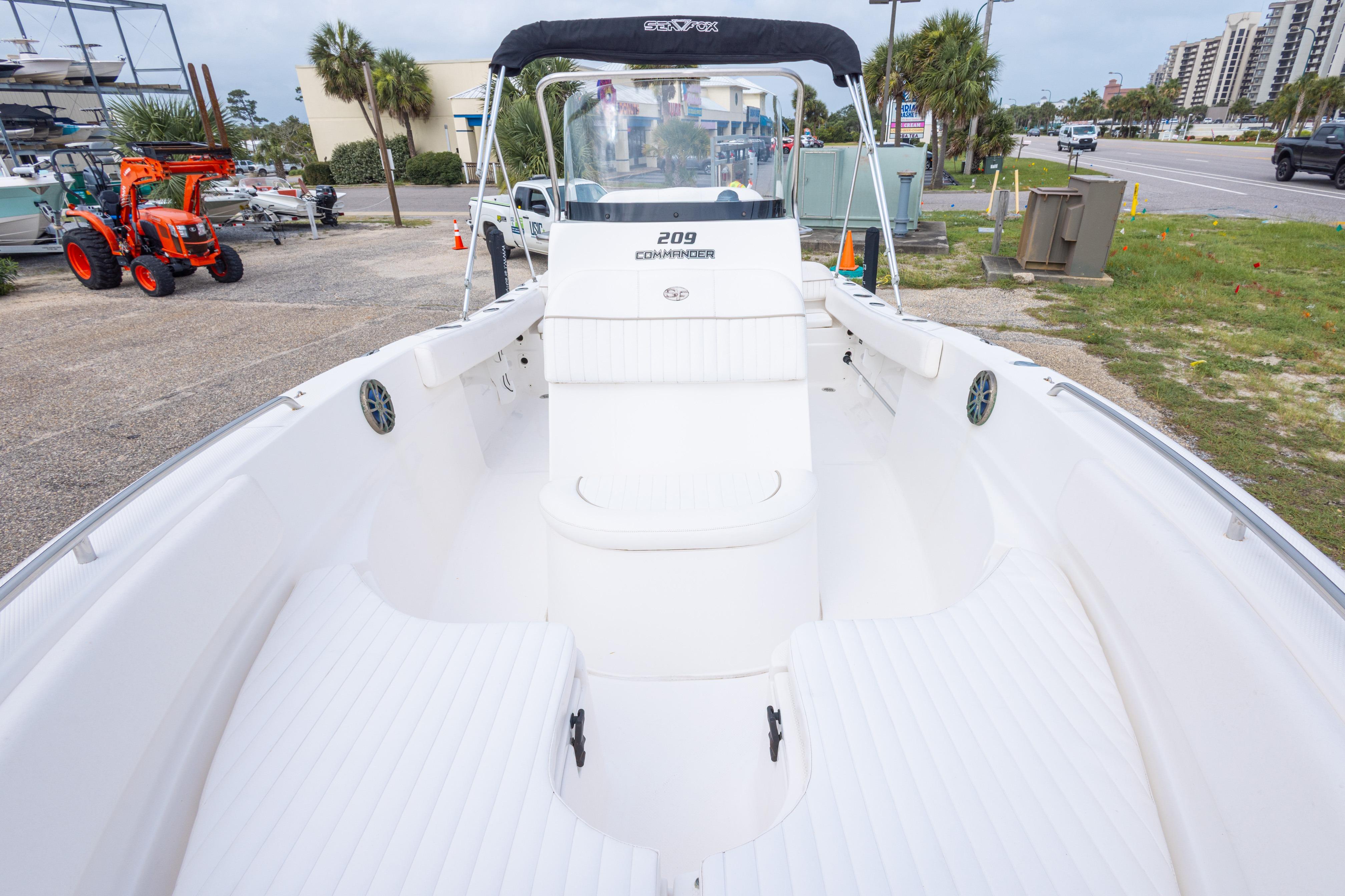 2014 Sea Fox 209 Commander boat with spacious deck, parked outdoors.