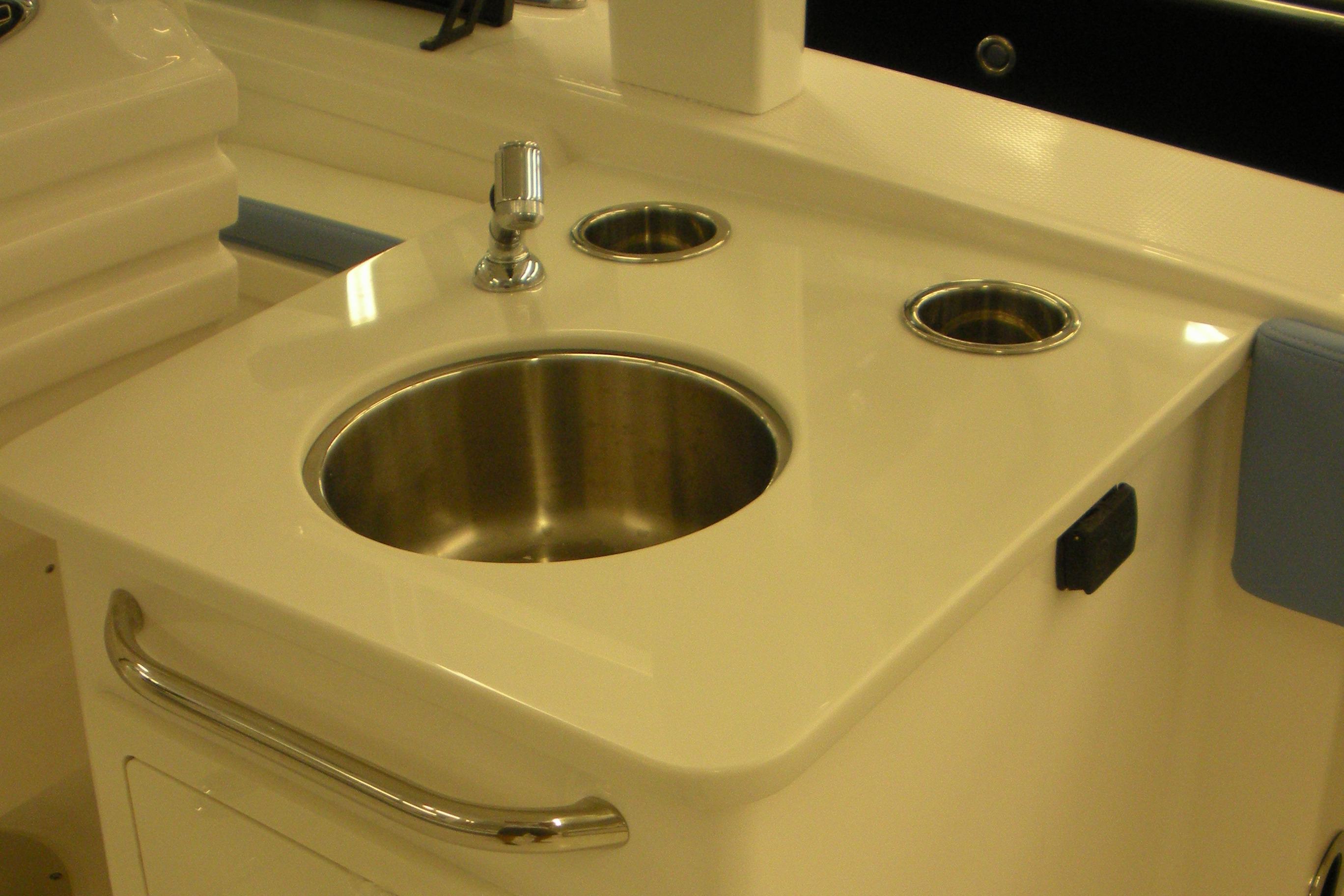 2026 Robalo R257 Dual Console boat sink with faucet and cup holders.