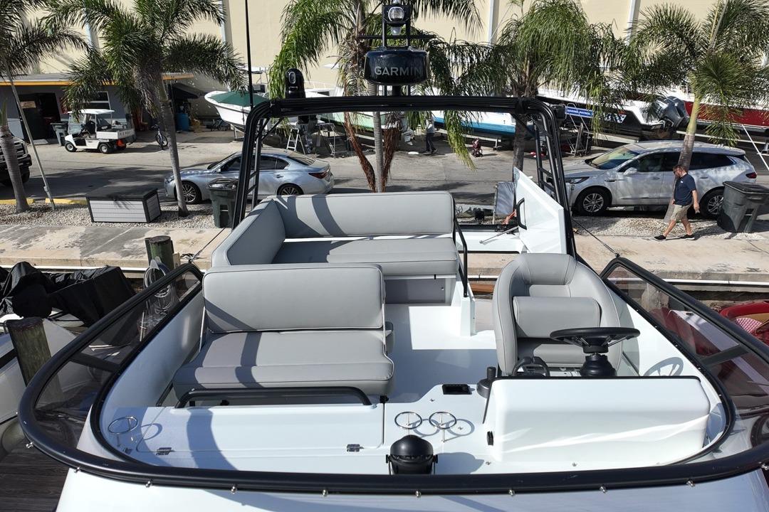 2026 Targa 41 boat interior with modern seating and steering, docked near palm trees.