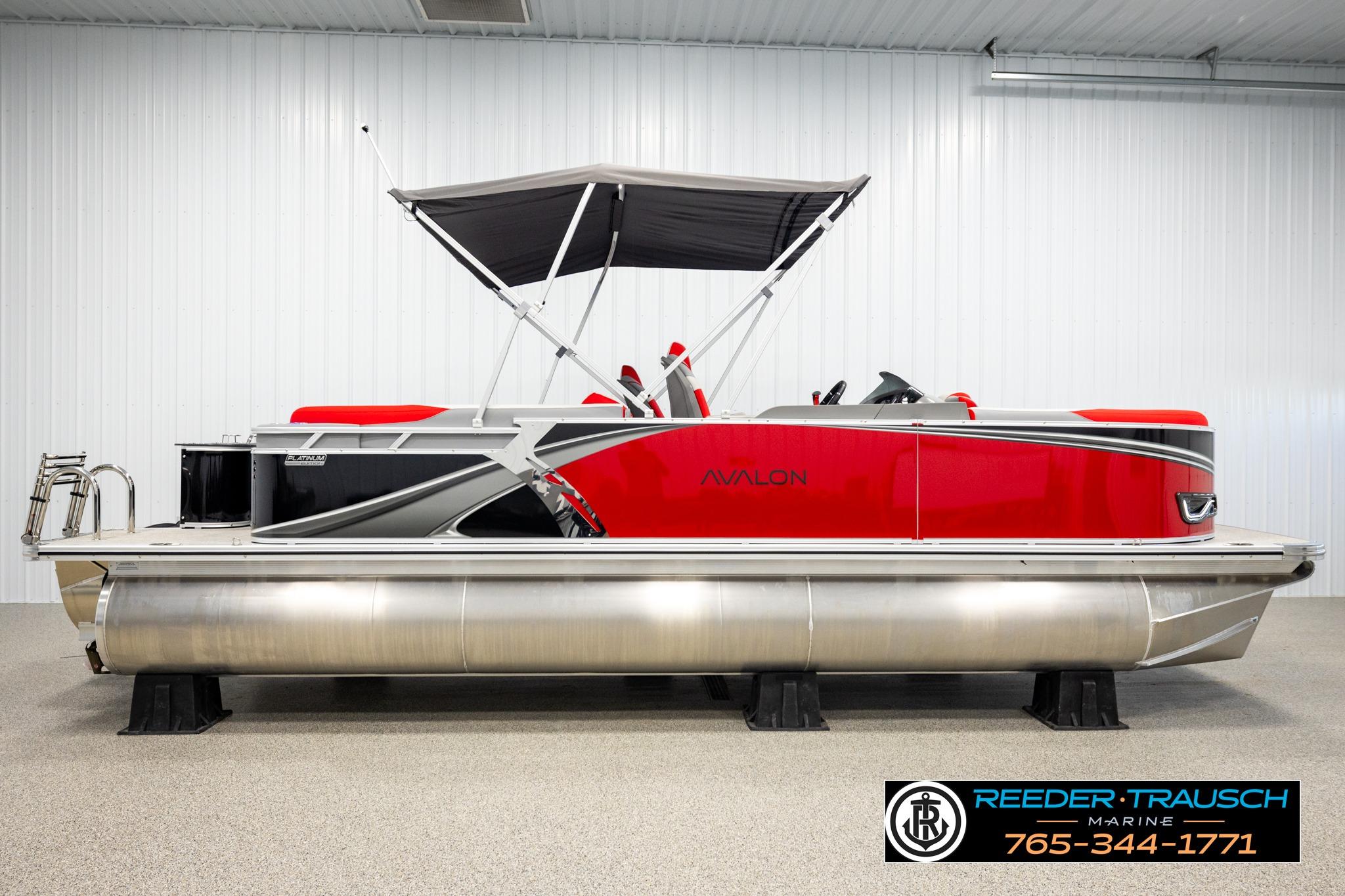 2026 Avalon LSZ QL pontoon boat with red and silver design in showroom.