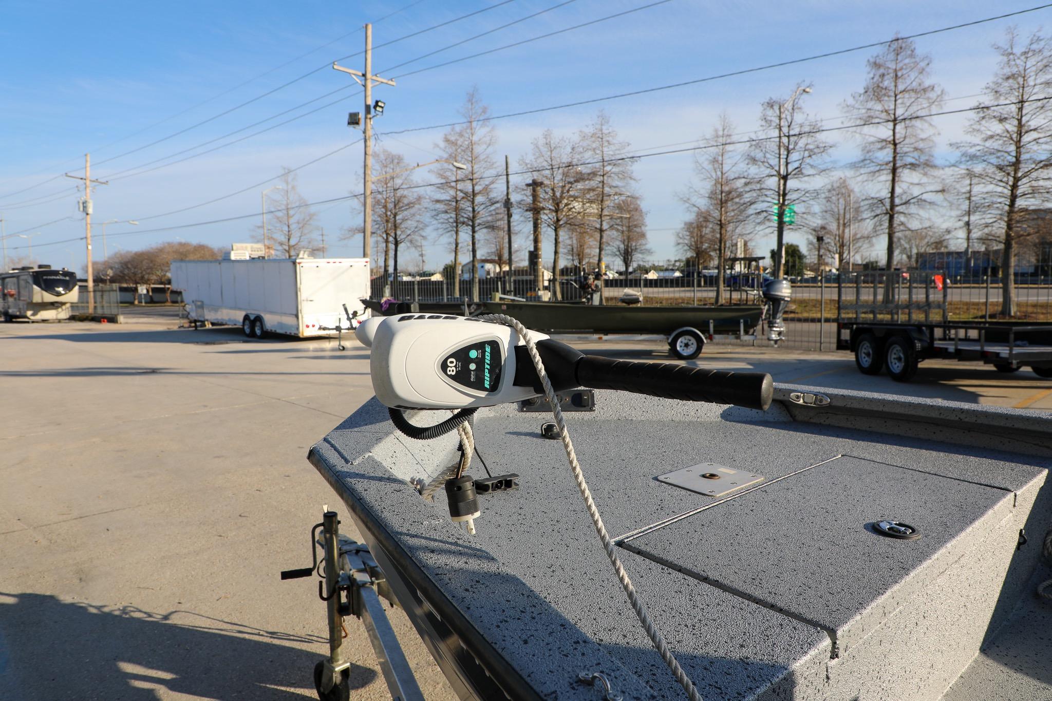 2019 Express 18 boat with trolling motor in a parking lot, trailers in background.