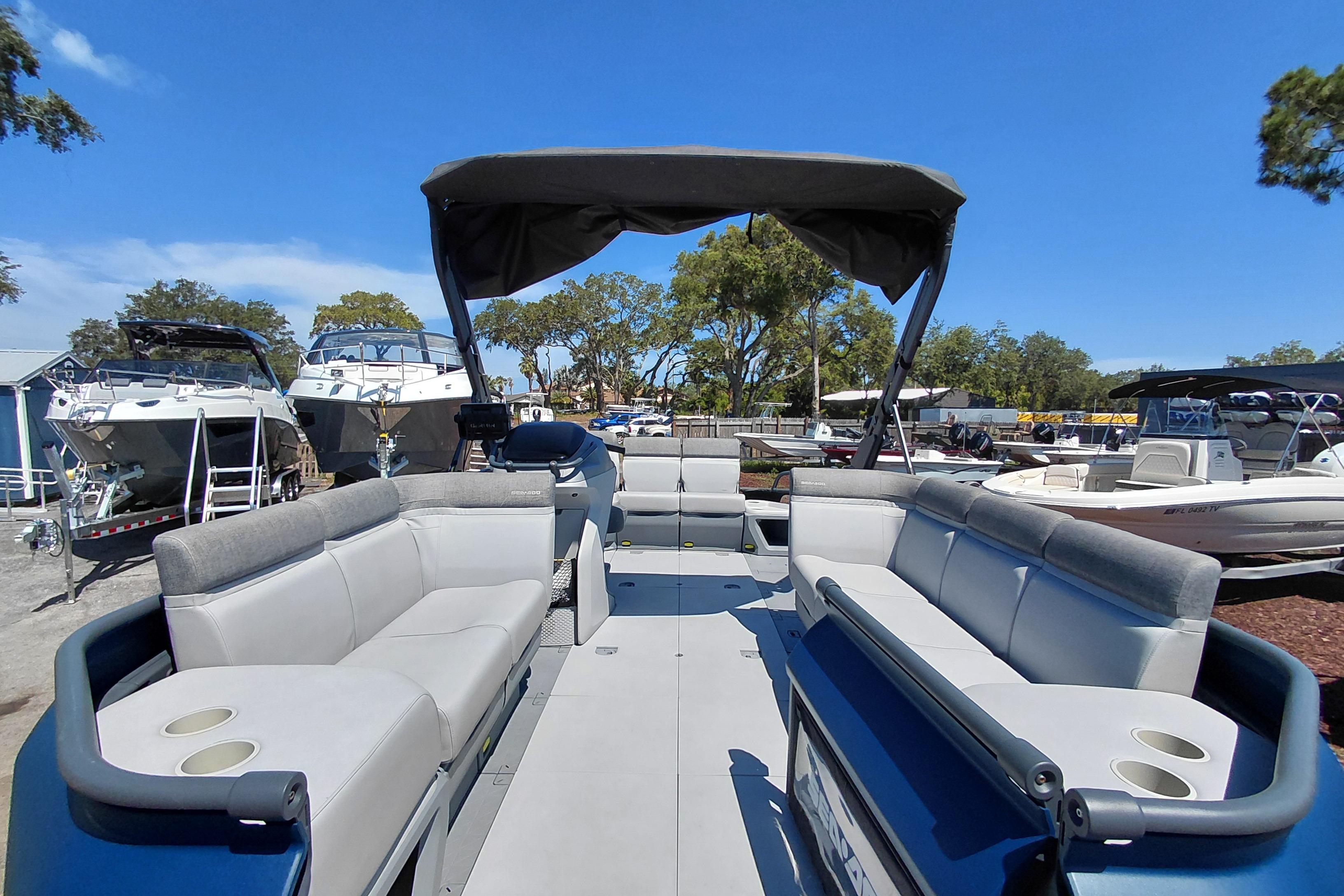 2024 Sea-Doo Switch Cruise 18 pontoon boat with spacious seating and canopy in a marina.