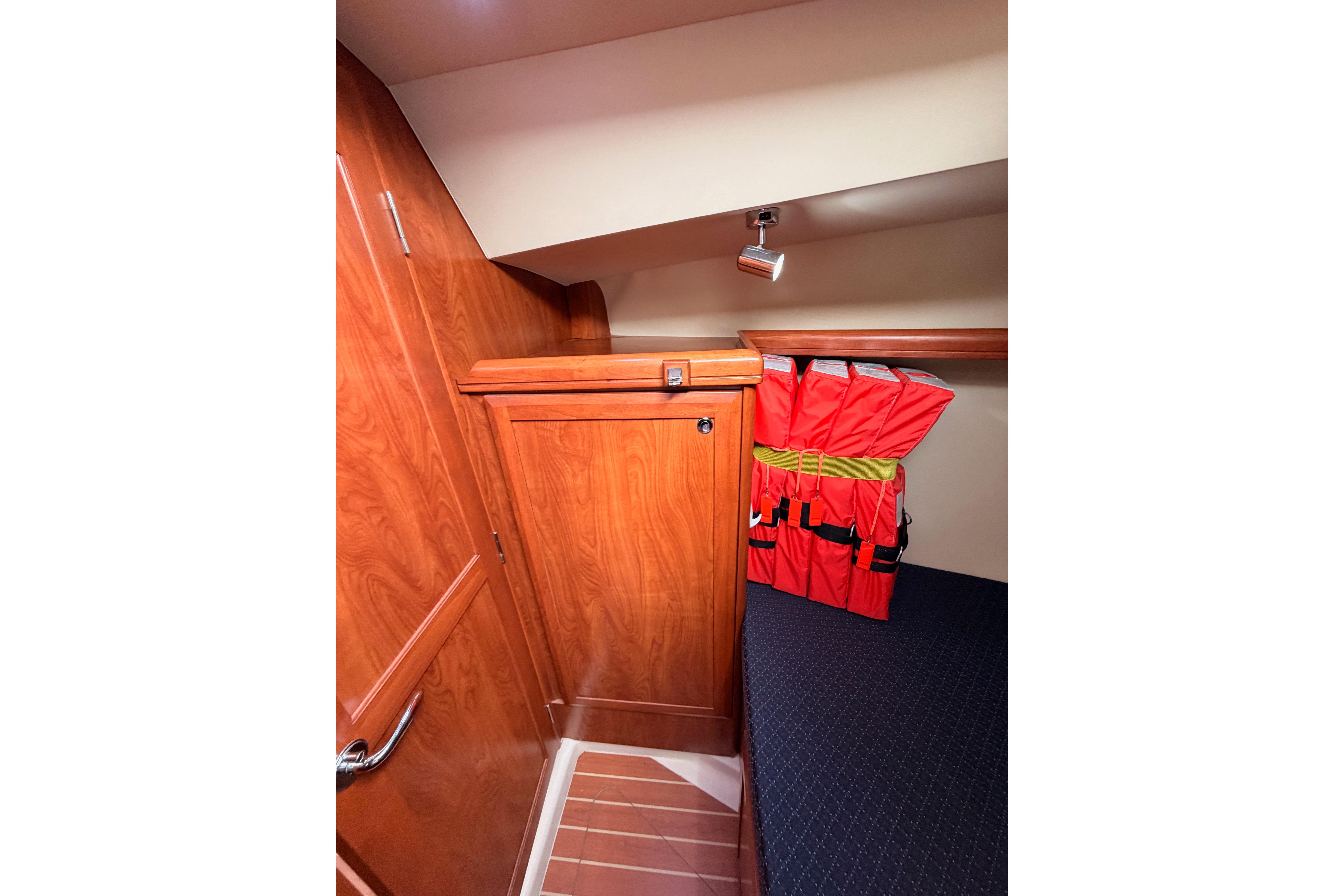 Interior of 2009 Hunter 38 sailboat with wooden cabinetry and life jackets.