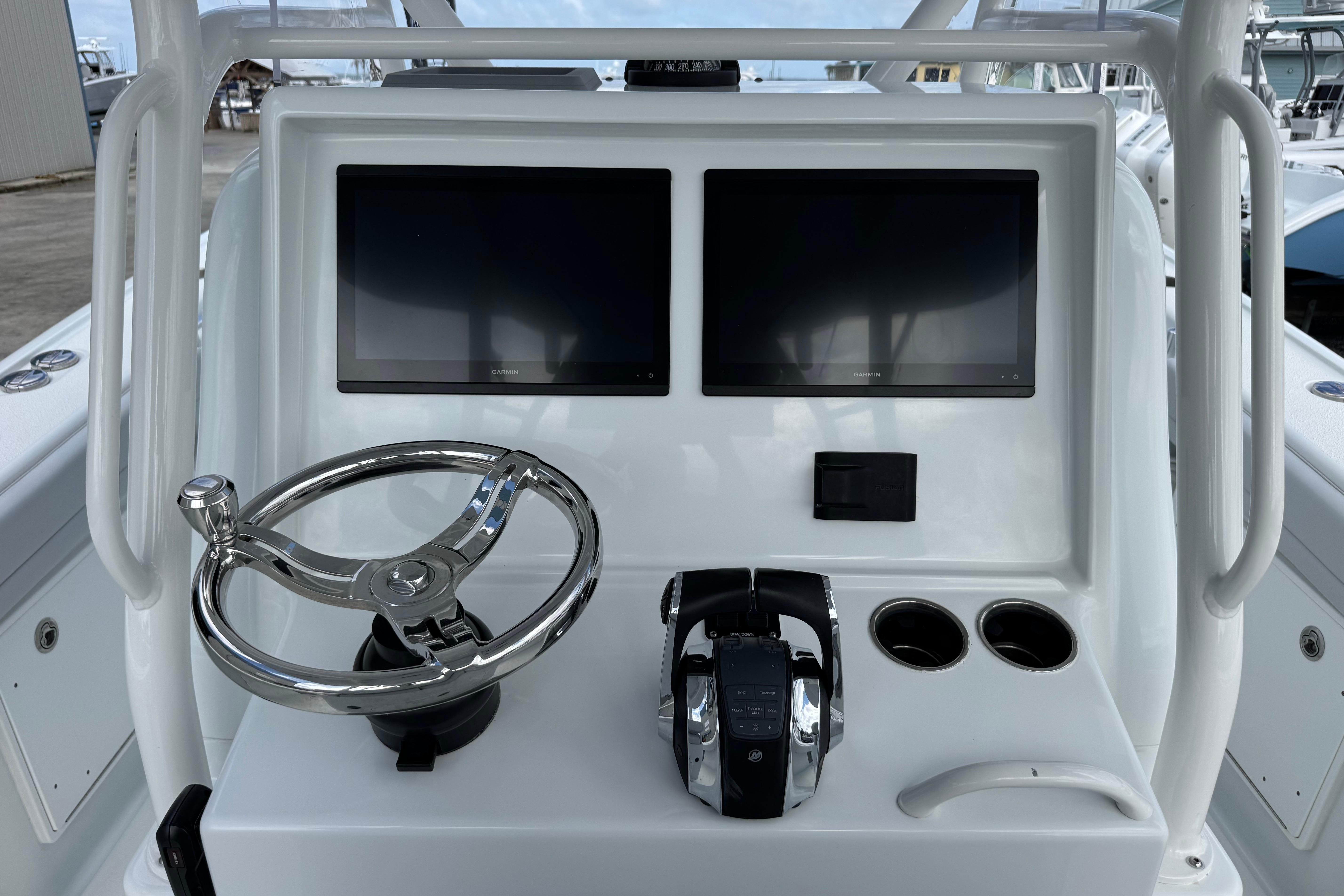 2022 Yellowfin 32 Offshore helm with dual screens, steering wheel, and controls.