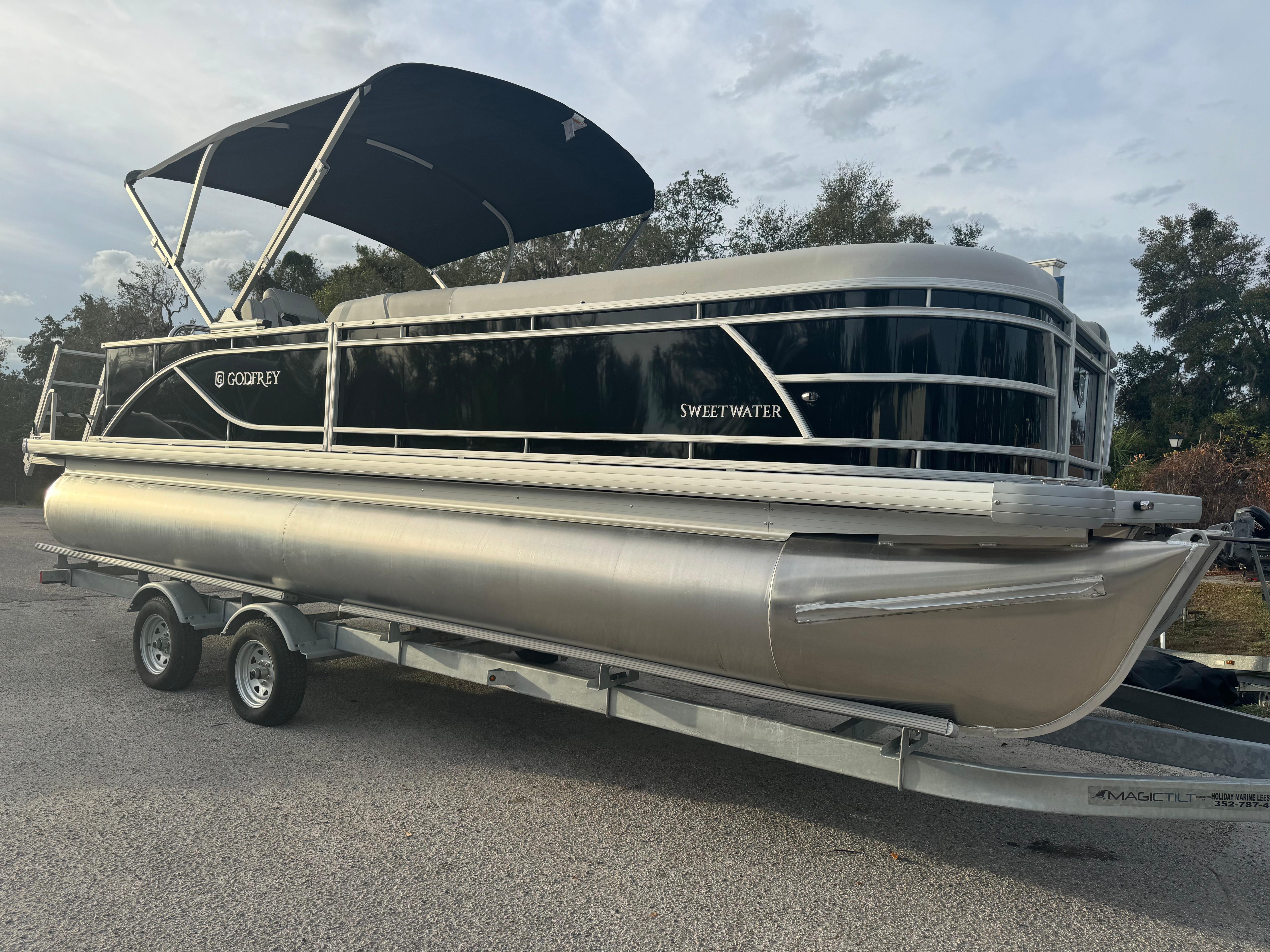2025 Sweetwater 2286 CSE pontoon boat on trailer, black and silver design.