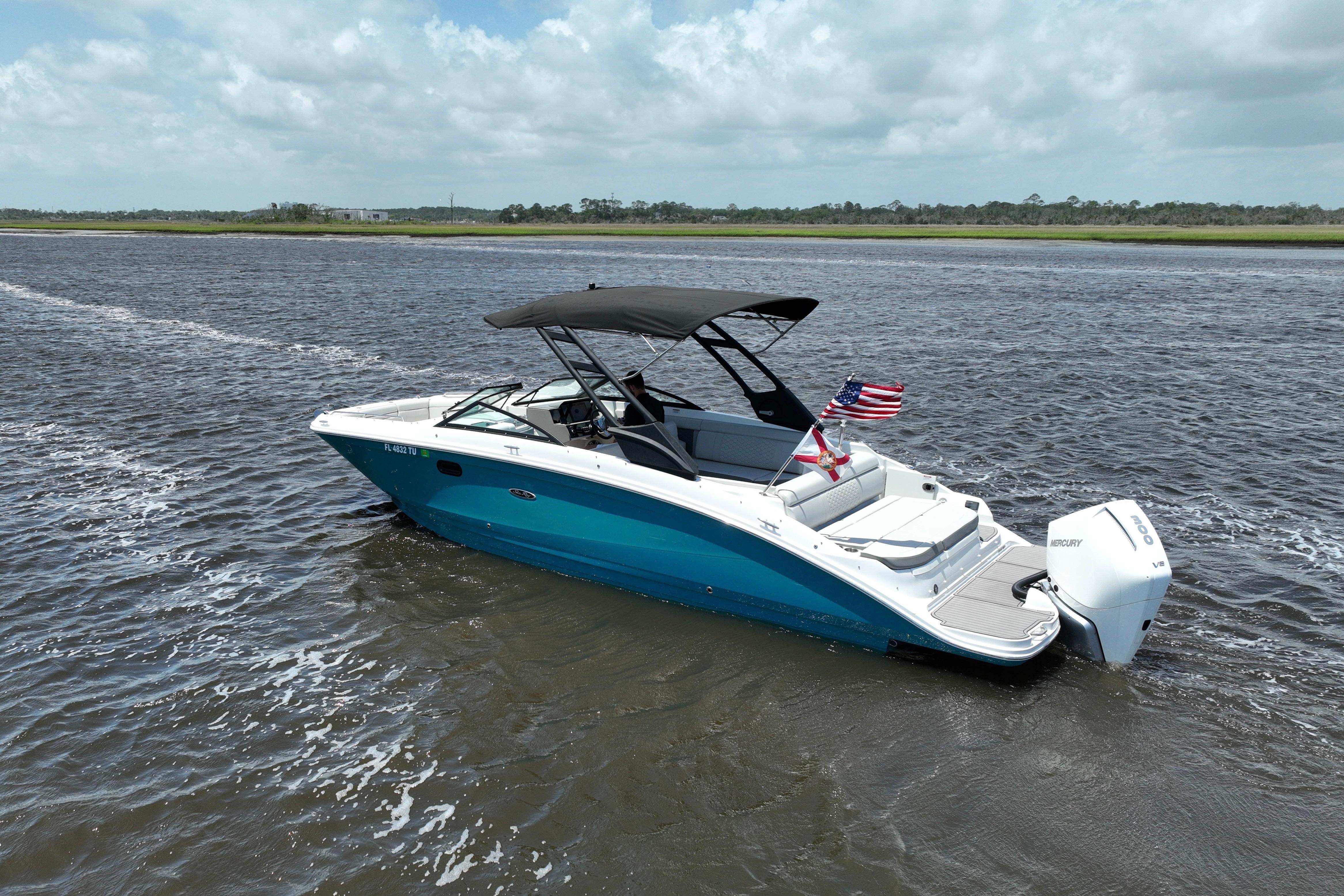 2024 Sea Ray SDX 270 Outboard boat cruising on a scenic waterway.