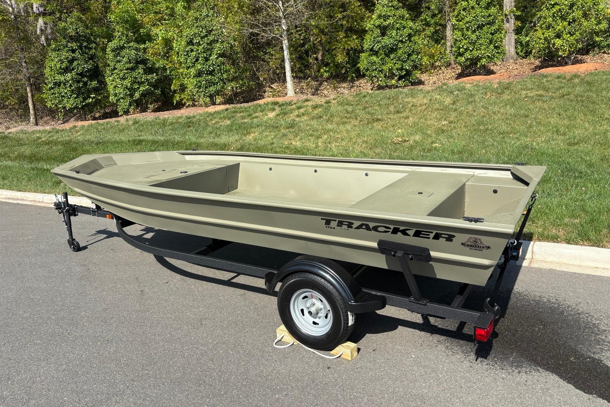 2026 Tracker Grizzly 1754 Utility boat on trailer, parked on a paved road.