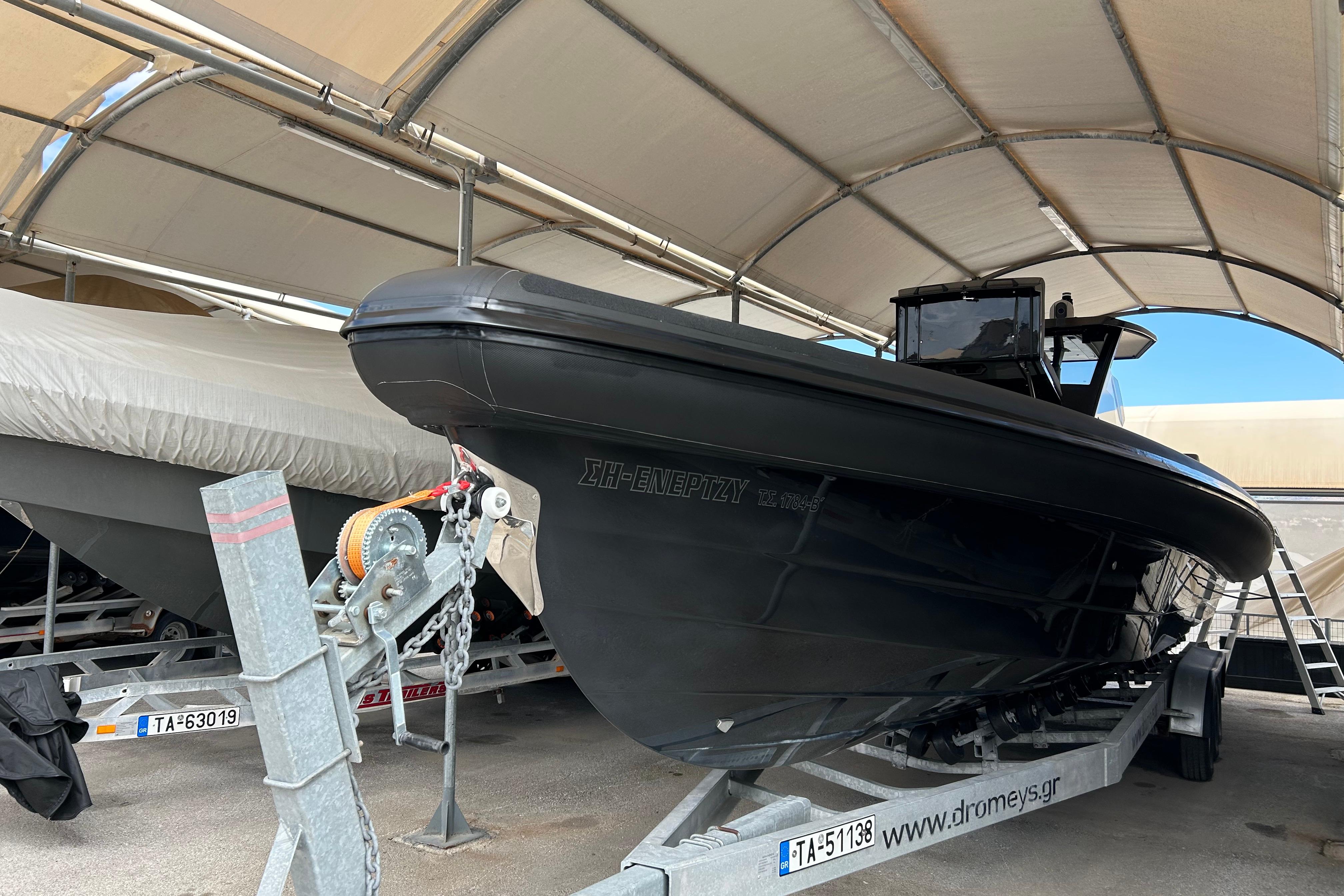 2022 Technohull 38 Grand Sport boat on trailer under canopy.