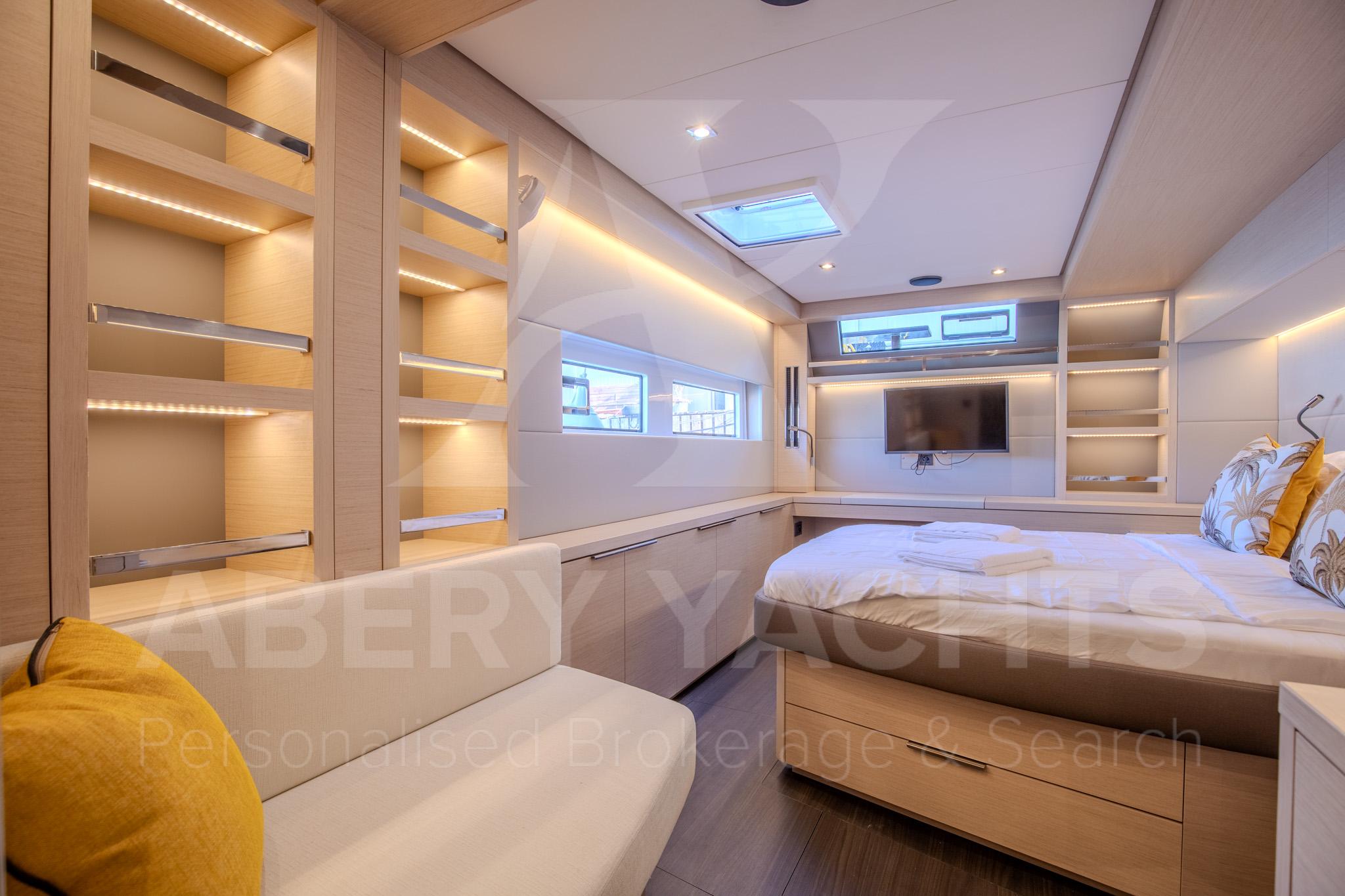 Luxurious interior of 2024 Lagoon 55 yacht with modern design and cozy bedroom.