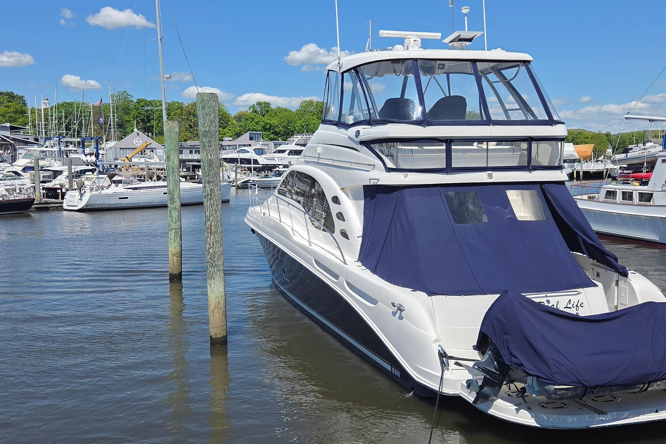 2007 Sea Ray 580 Sedan Bridge yacht docked in a marina under a clear blue sky.